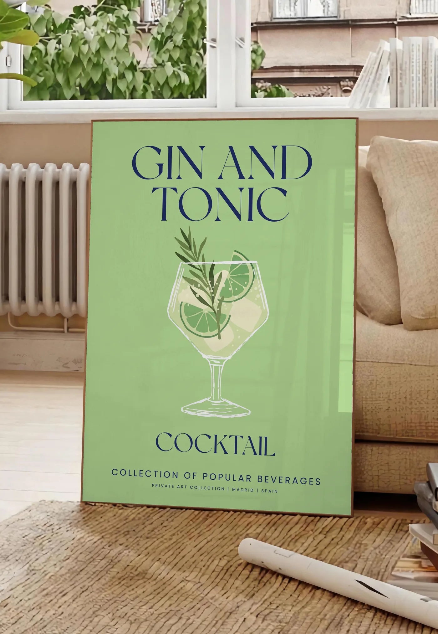 Poster affiche cocktail Gin Tonic, posee au sol dans un salon parisien, devant une grande fenetre donnant sur un immeuble haussmannien, entre un ficus et un canape creme