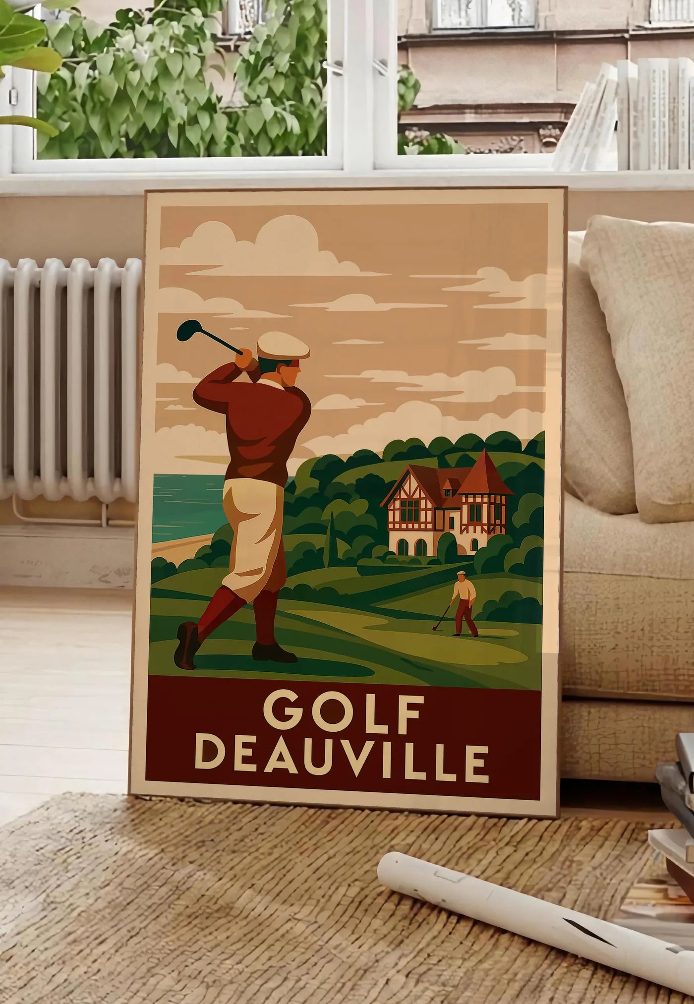 Poster golfeur en swing face à la mer, posee au sol dans un salon parisien, devant une grande fenetre donnant sur un immeuble haussmannien, entre un ficus et un canape creme