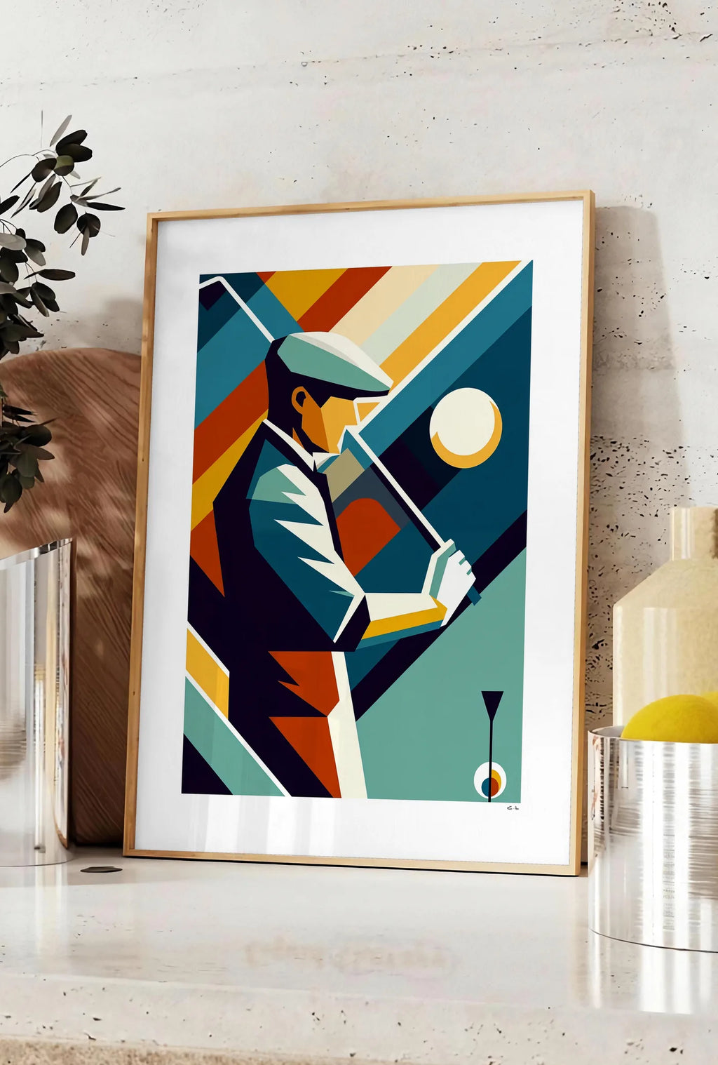 Affiche affiche golf cubiste Art Deco, posee sur un plan de travail de cuisine en pierre claire, entre une branche d'eucalyptus en vase et un bocal de citrons