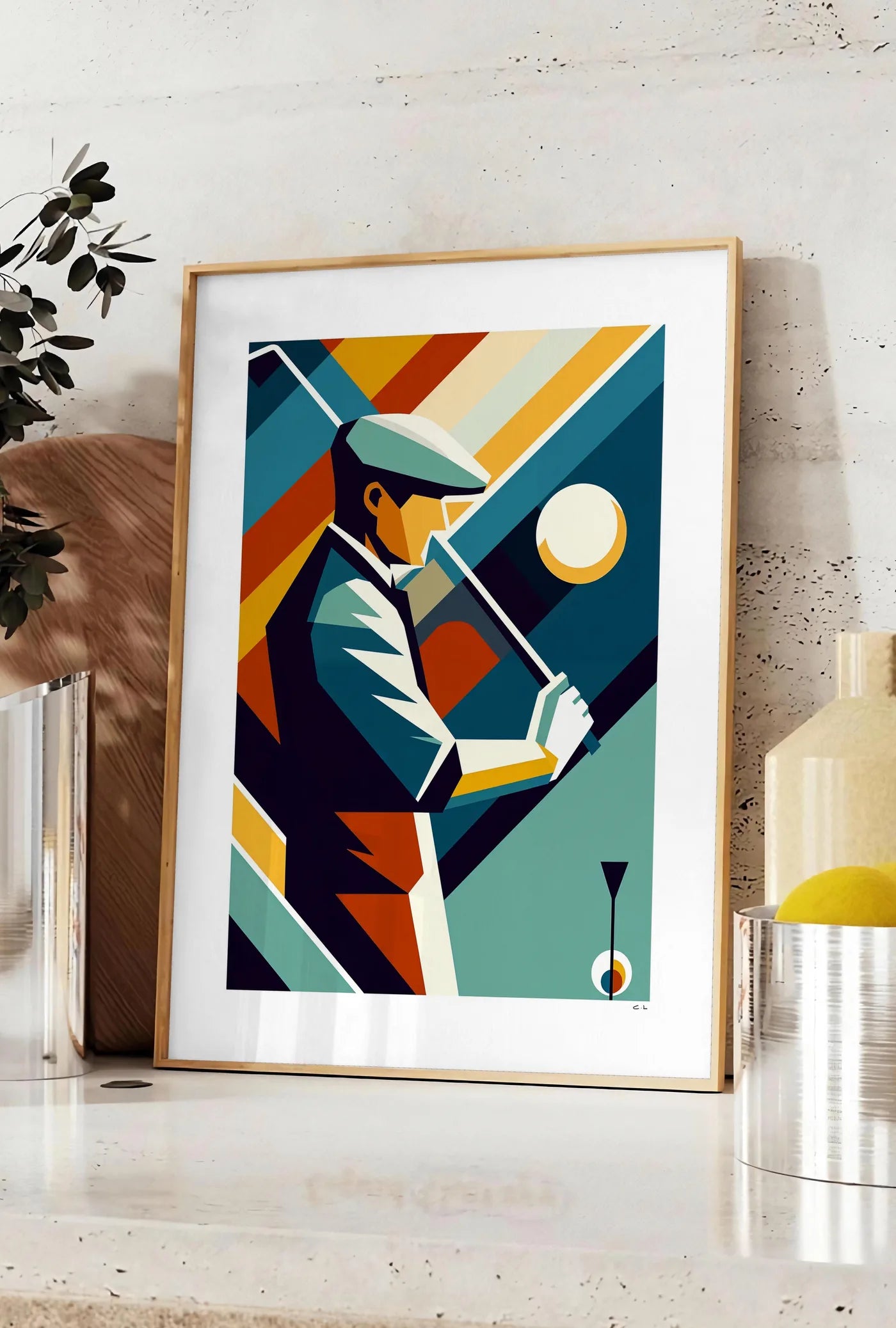 Affiche affiche golf cubiste Art Deco, posee sur un plan de travail de cuisine en pierre claire, entre une branche d'eucalyptus en vase et un bocal de citrons