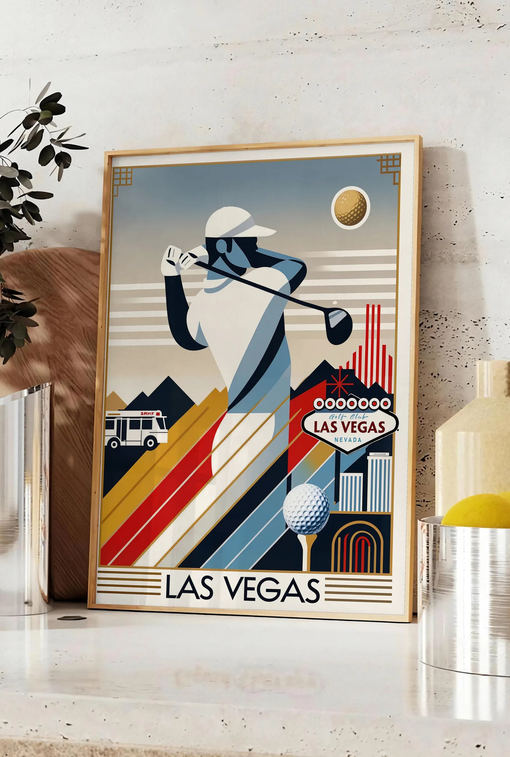 Affiche golfeur stylisé en pleine frappe, posee sur un plan de travail de cuisine en pierre claire, entre une branche d'eucalyptus en vase et un bocal de citrons