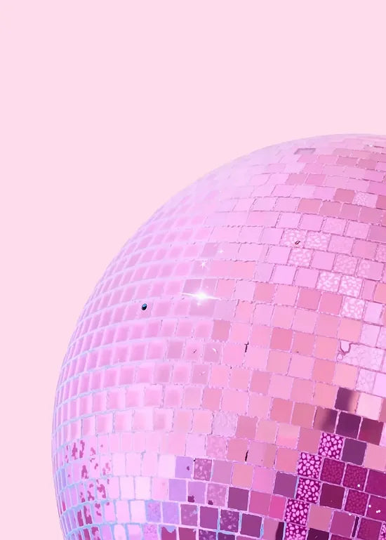 Gros plan sur les facettes pailletees de la boule disco rose