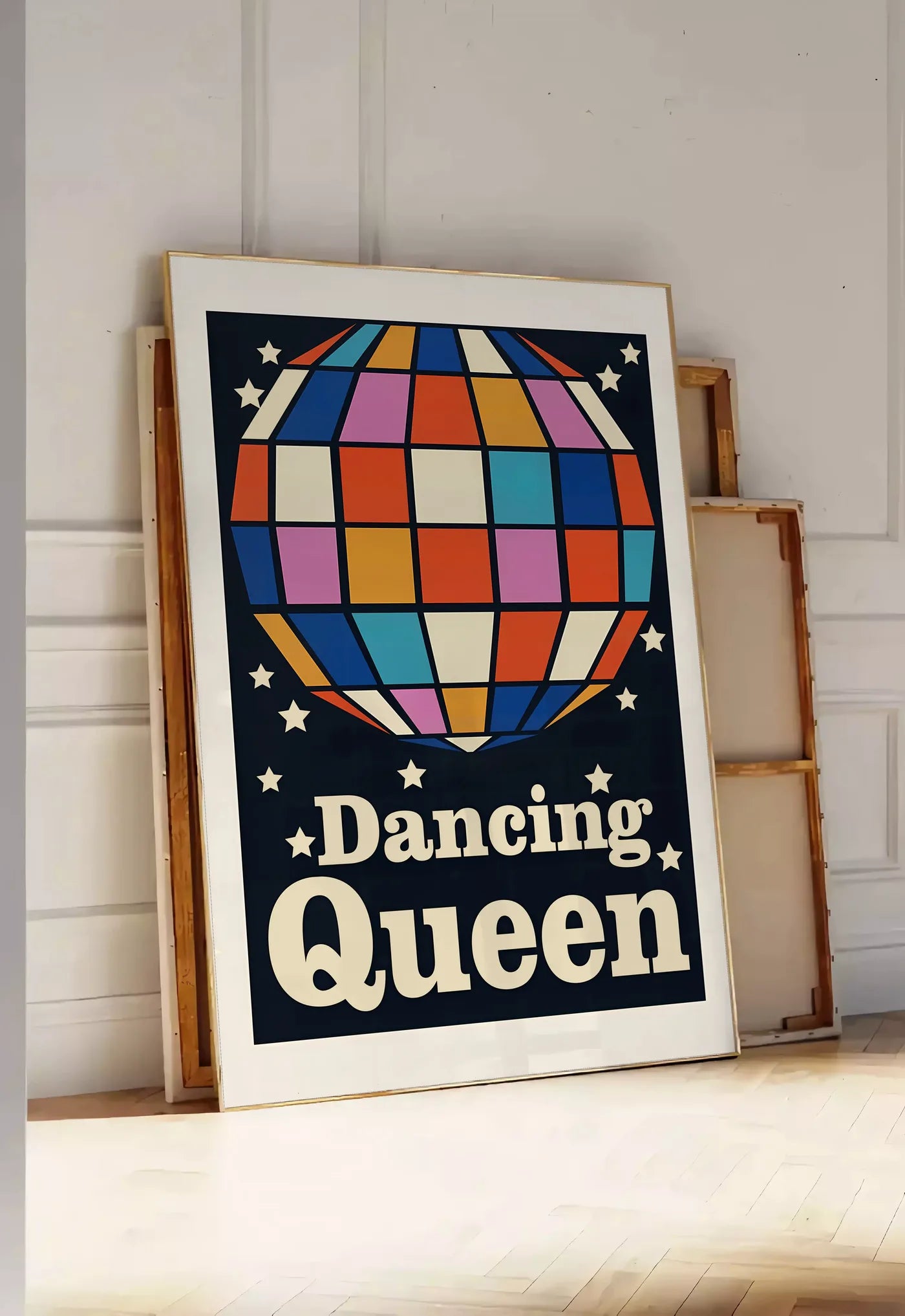 Tirage encadrable affiche vintage Dancing Queen, posee au sol dans une entree lumineuse, contre un mur a panneaux blancs, a cote de chassis en bois empiles