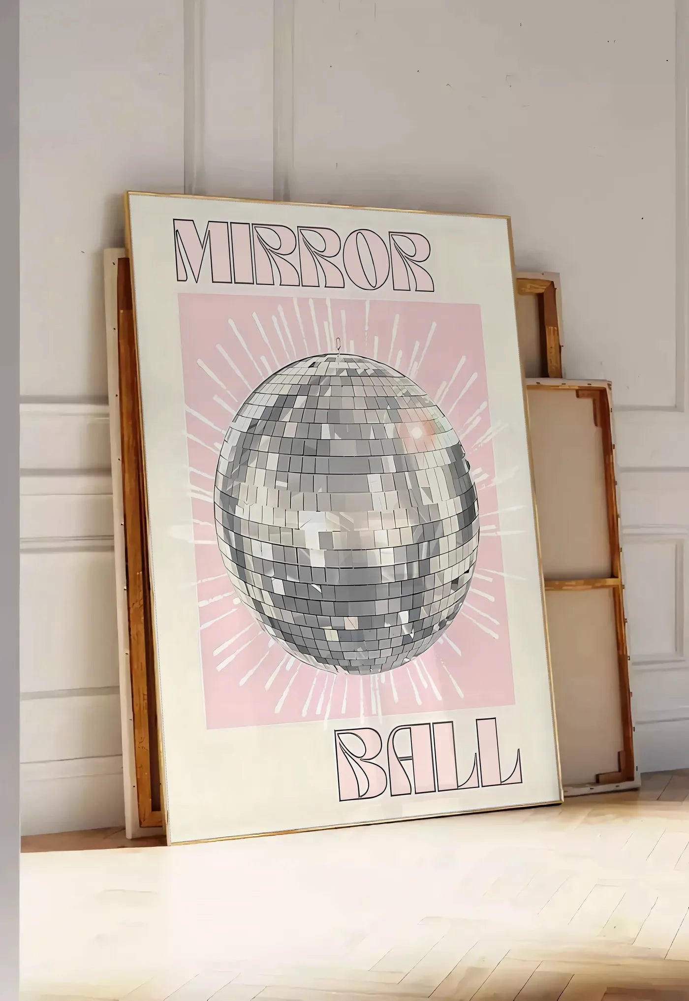 Tirage encadrable affiche vintage Mirror Ball, posee au sol dans une entree lumineuse, contre un mur a panneaux blancs, a cote de chassis en bois empiles