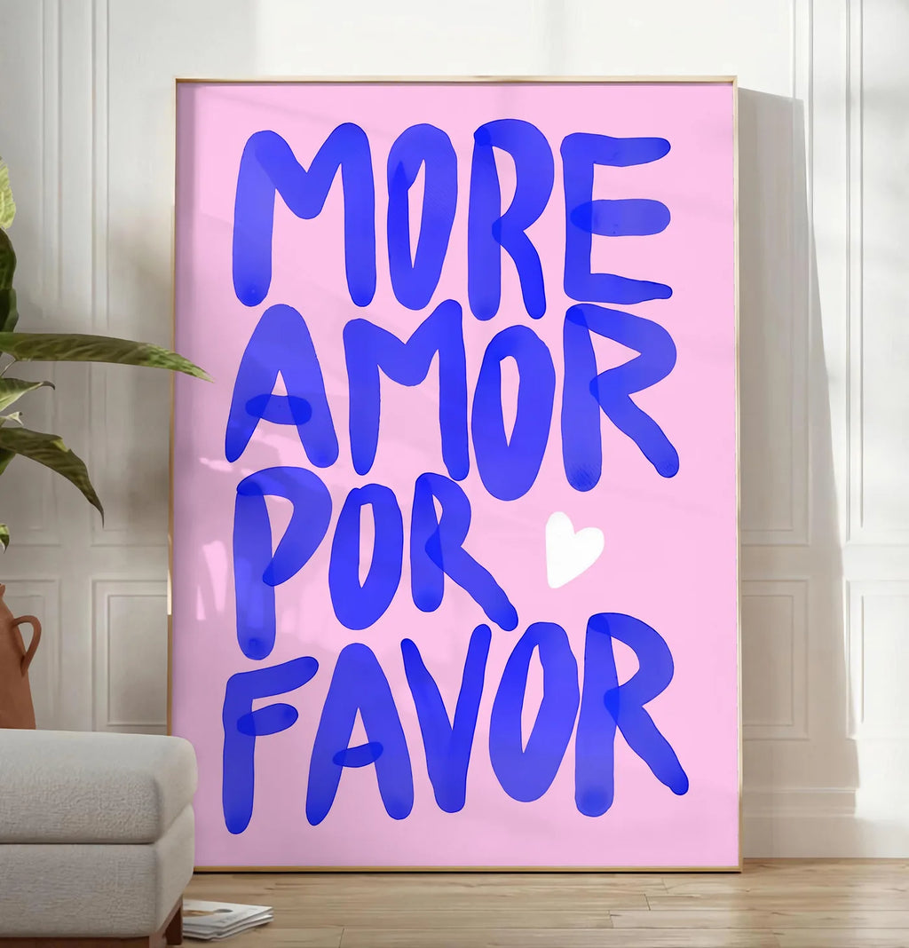 Reproduction affiche vintage More Amor Por Favor, posee au sol dans un salon minimaliste clair, a cote d'un canape beige et d'une plante verte, sur un parquet clair