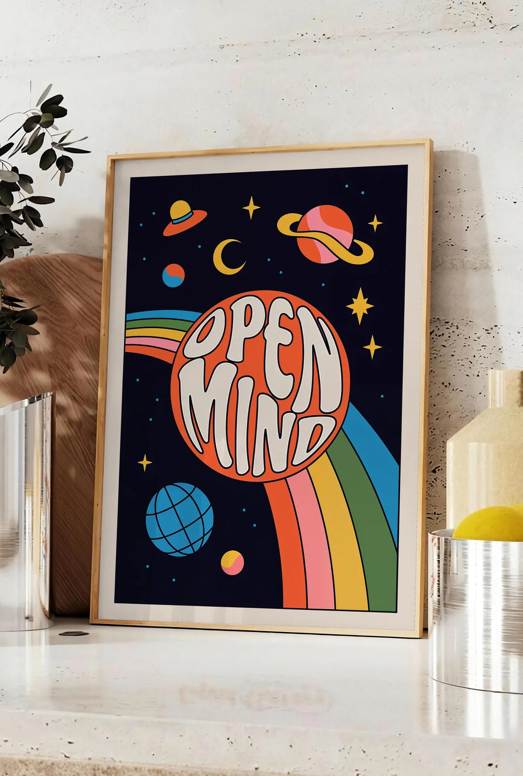 Affiche affiche vintage Open Mind, posee sur un plan de travail de cuisine en pierre claire, entre une branche d'eucalyptus en vase et un bocal de citrons