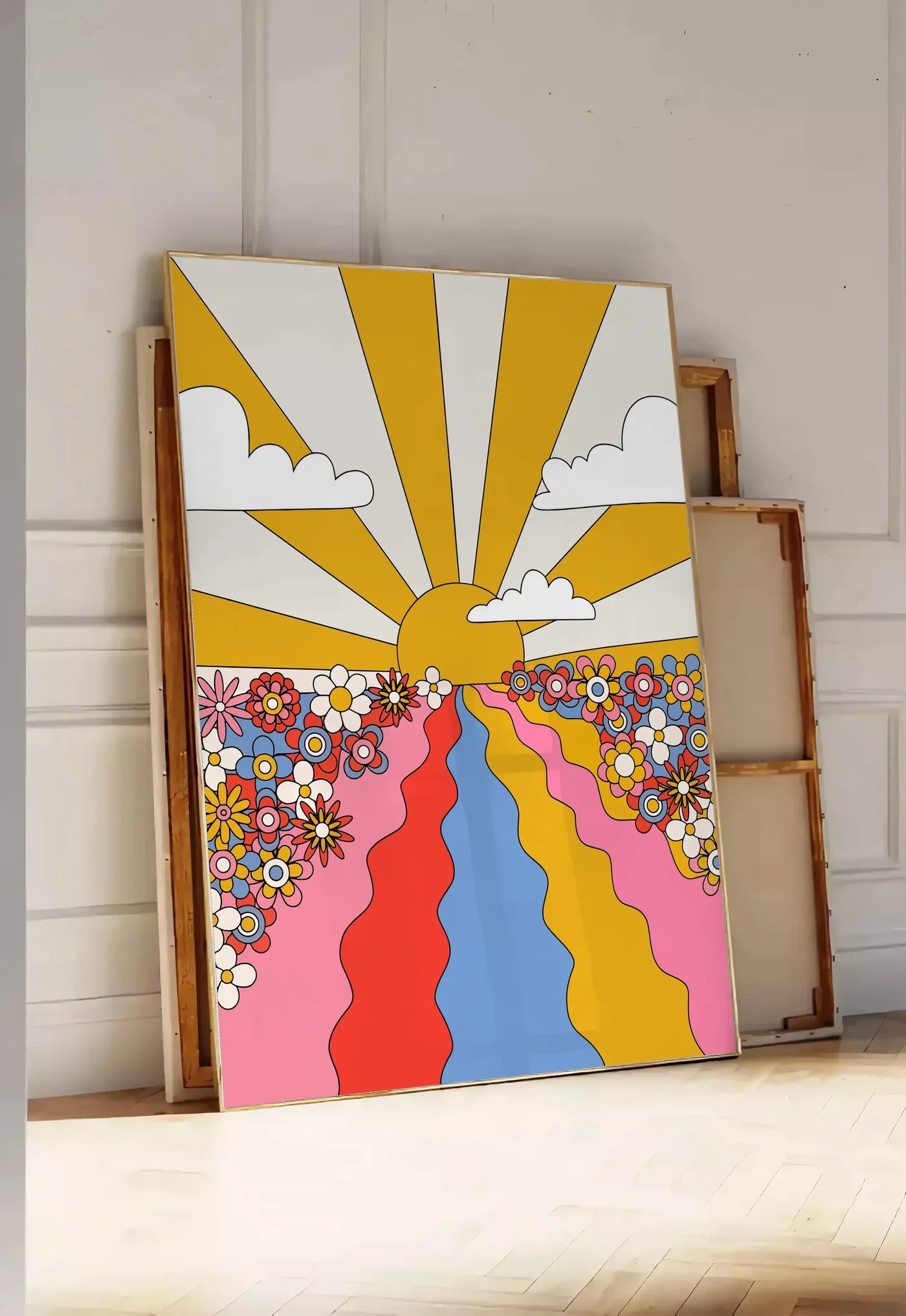 Tirage encadrable soleil aux rayons jaunes fleurs et chemin ondule, posee au sol dans une entree lumineuse, contre un mur a panneaux blancs, a cote de chassis en bois empiles