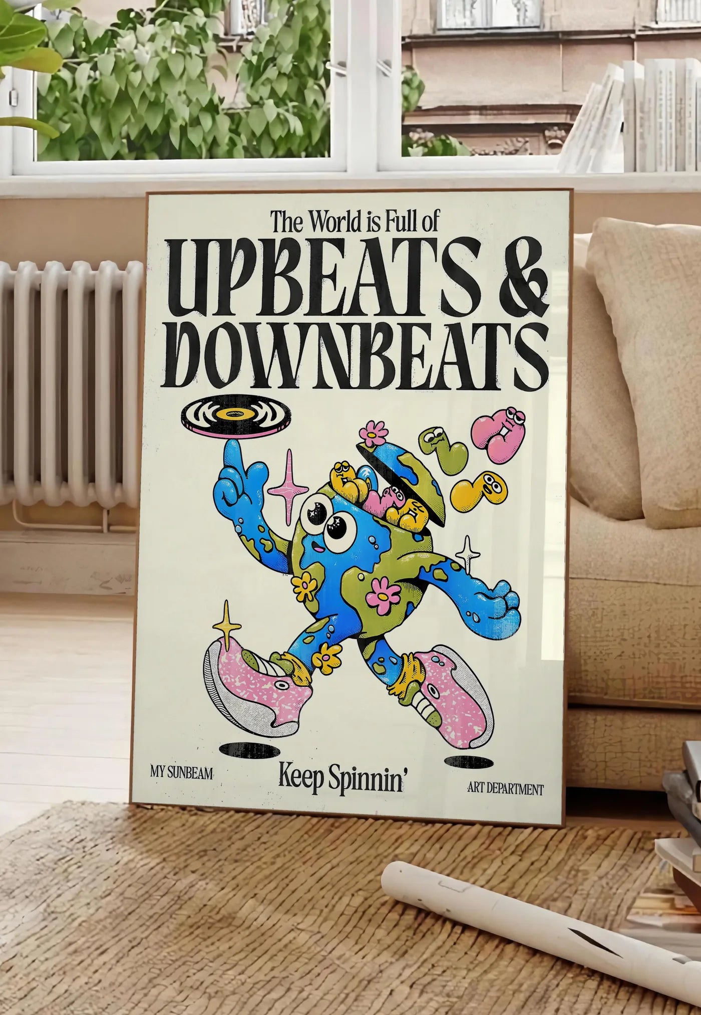 Poster affiche vintage Upbeats and Downbeats, posee au sol dans un salon parisien, devant une grande fenetre donnant sur un immeuble haussmannien, entre un ficus et un canape creme