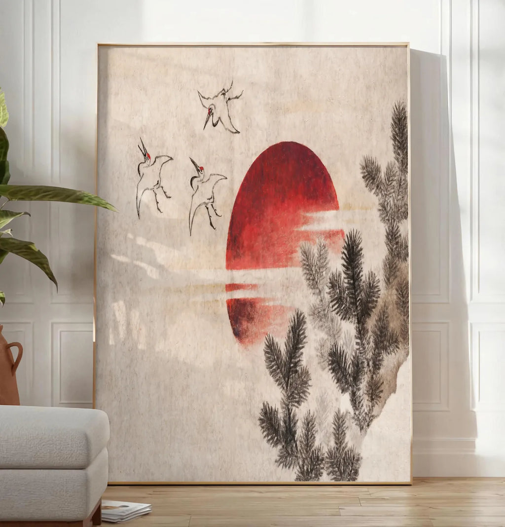 Reproduction affiche grues et soleil rouge art japonais, posee au sol dans un salon minimaliste clair, a cote d'un canape beige et d'une plante verte, sur un parquet clair