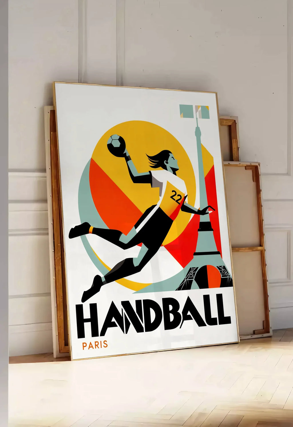 Tirage encadrable affiche handball Paris, posee au sol dans une entree lumineuse, contre un mur a panneaux blancs, a cote de chassis en bois empiles