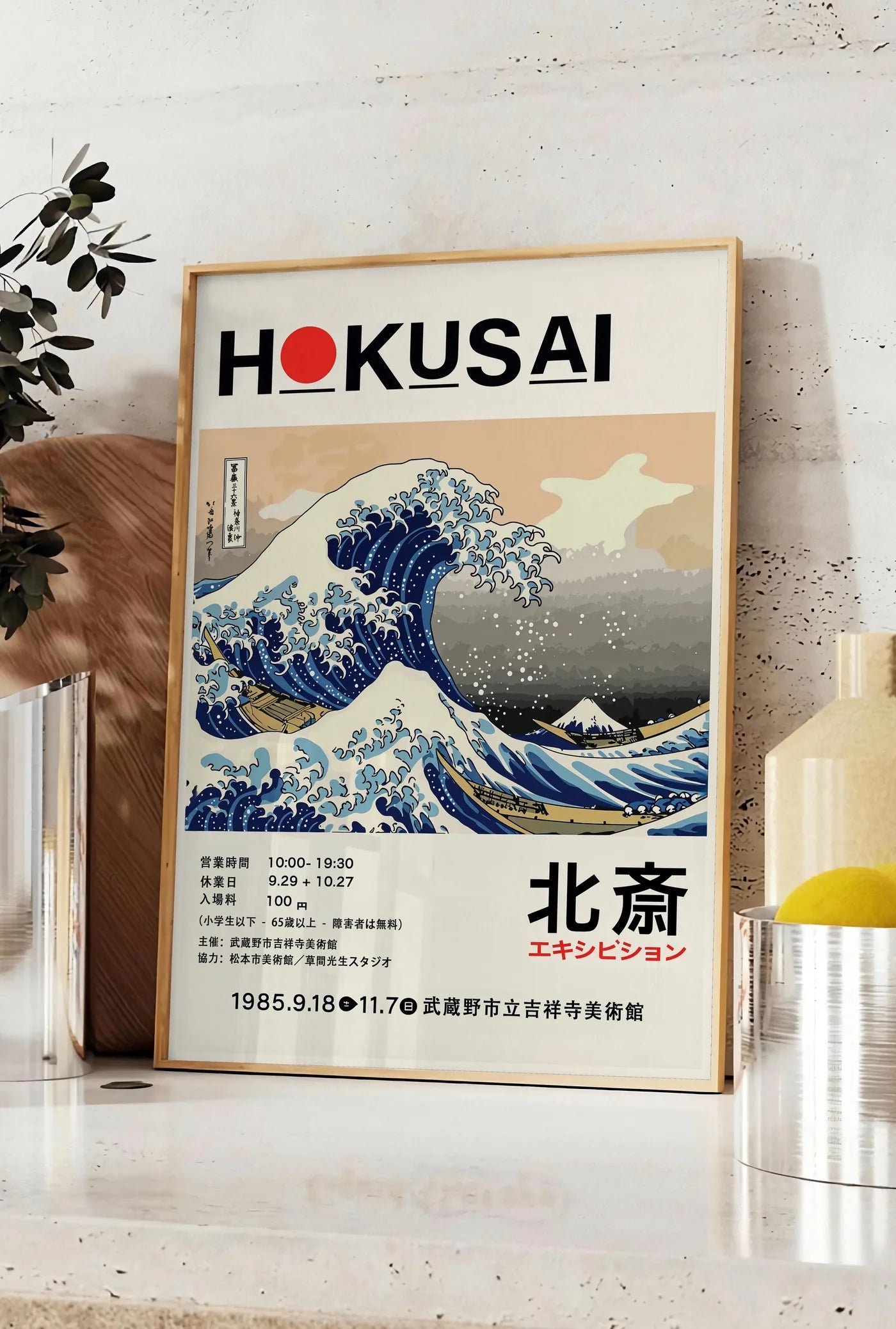 Affiche affiche Hokusai grande vague de Kanagawa, posee sur un plan de travail de cuisine en pierre claire, entre une branche d'eucalyptus en vase et un bocal de citrons