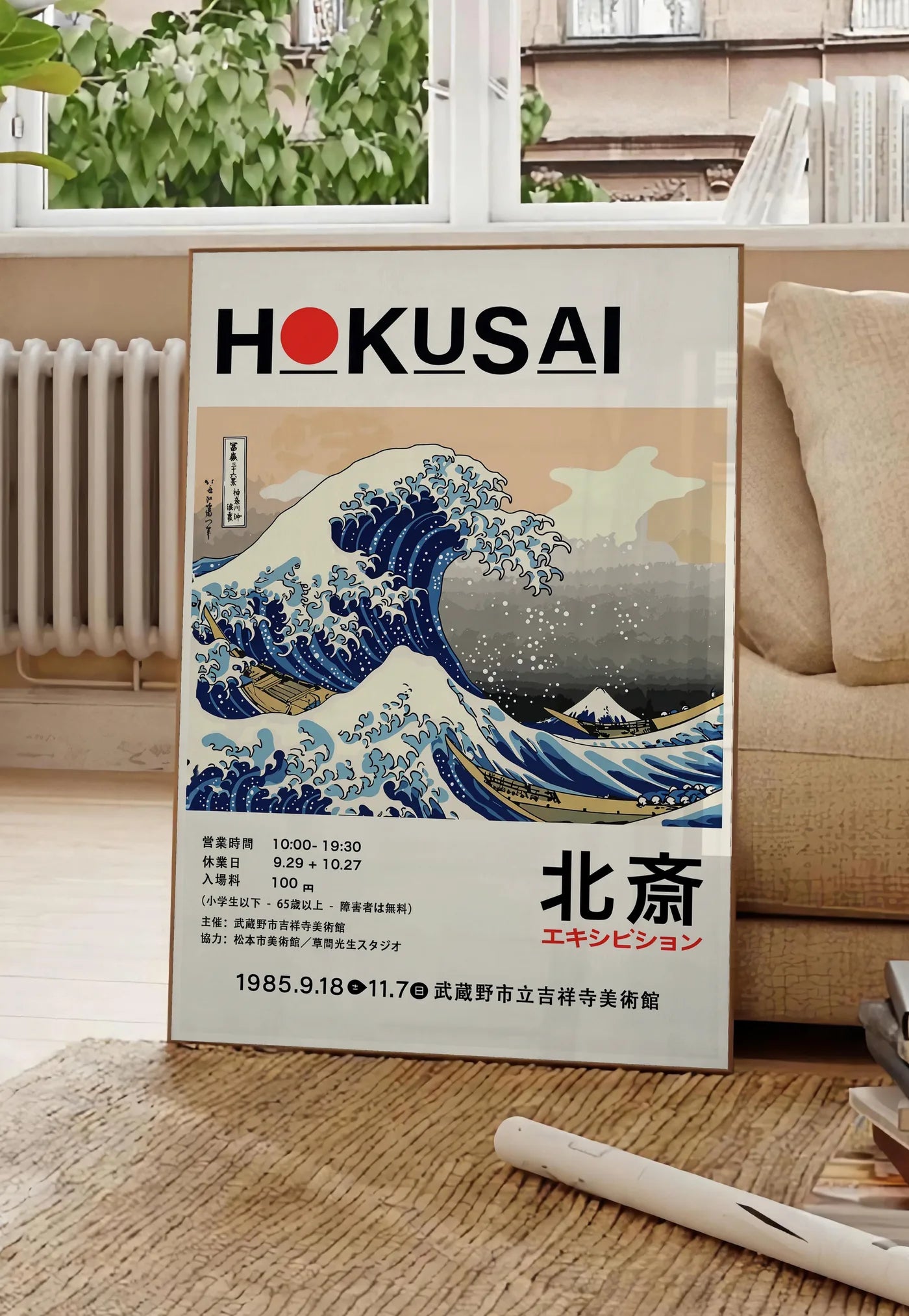 Poster affiche Hokusai grande vague de Kanagawa, posee au sol dans un salon parisien, devant une grande fenetre donnant sur un immeuble haussmannien, entre un ficus et un canape creme