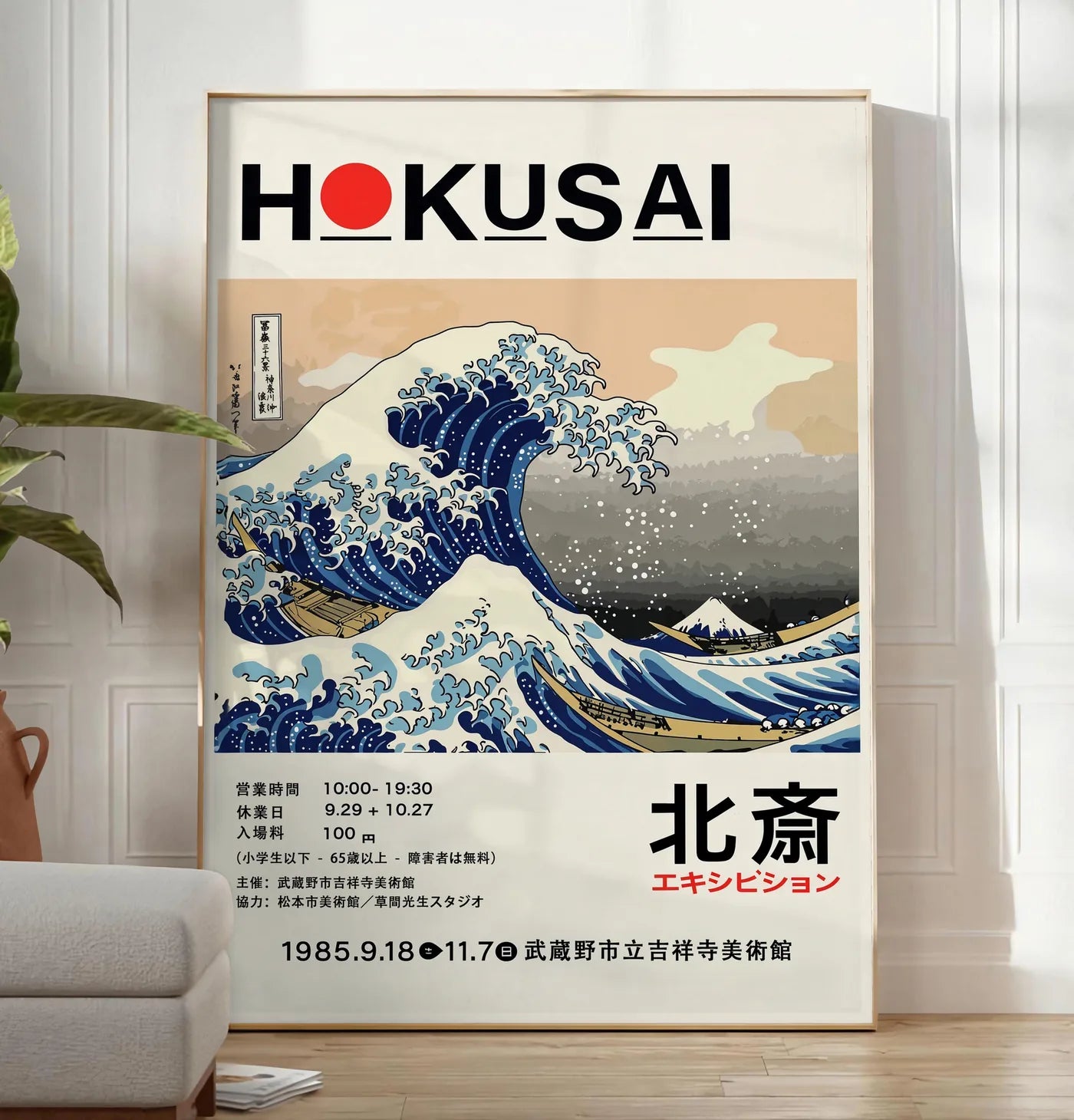 Reproduction affiche Hokusai grande vague de Kanagawa, posee au sol dans un salon minimaliste clair, a cote d'un canape beige et d'une plante verte, sur un parquet clair