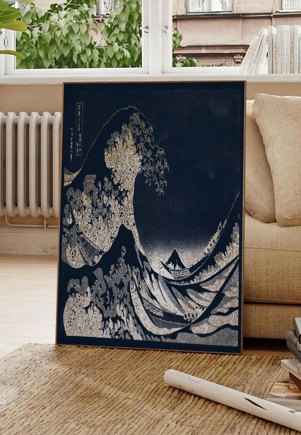 Poster affiche Hokusai grande vague doree sur bleu nuit, posee au sol dans un salon parisien, devant une grande fenetre donnant sur un immeuble haussmannien, entre un ficus et un canape creme