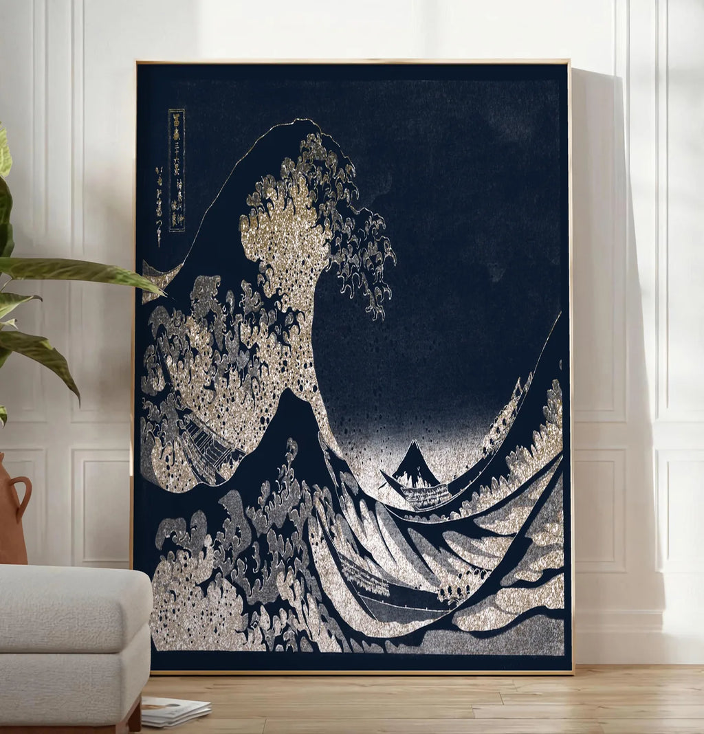 Reproduction affiche Hokusai grande vague doree sur bleu nuit, posee au sol dans un salon minimaliste clair, a cote d'un canape beige et d'une plante verte, sur un parquet clair