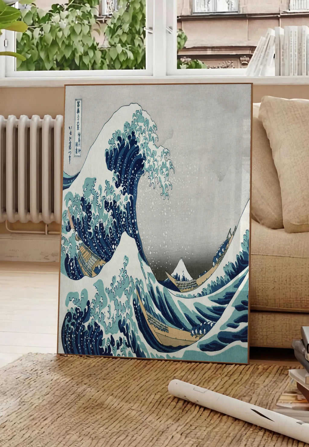 Poster affiche grande vague de Hokusai art japonais, posee au sol dans un salon parisien, devant une grande fenetre donnant sur un immeuble haussmannien, entre un ficus et un canape creme