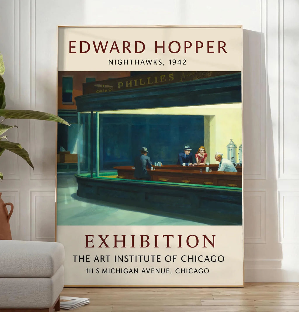 Reproduction affiche Hopper Nighthawks, posee au sol dans un salon minimaliste clair, a cote d'un canape beige et d'une plante verte, sur un parquet clair