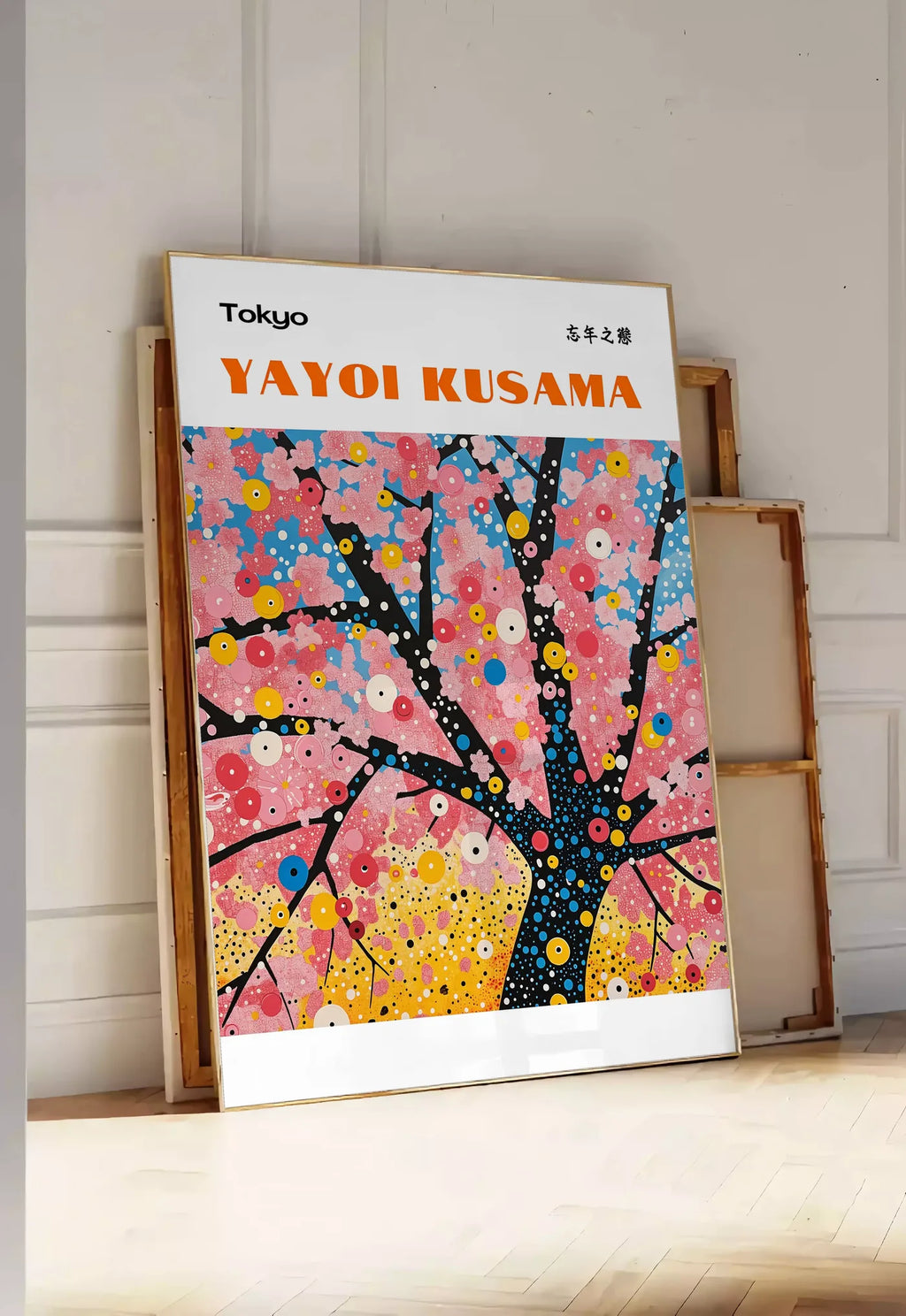 Tirage encadrable affiche cerisier a pois de Kusama art japonais, posee au sol dans une entree lumineuse, contre un mur a panneaux blancs, a cote de chassis en bois empiles