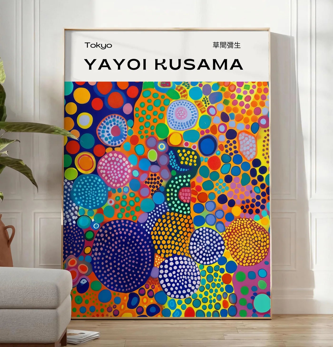 Reproduction affiche cercles multicolores de Kusama art japonais, posee au sol dans un salon minimaliste clair, a cote d'un canape beige et d'une plante verte, sur un parquet clair