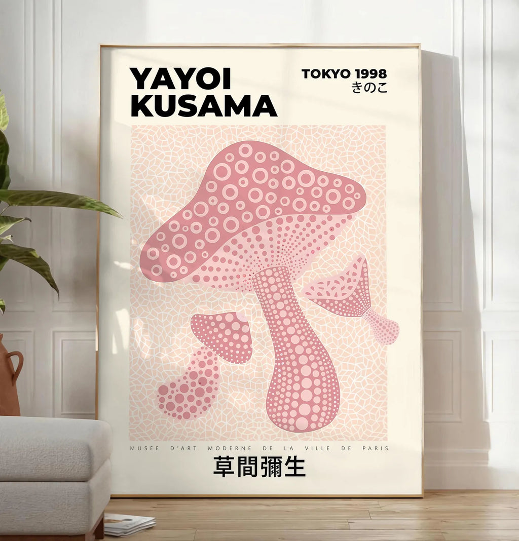Reproduction affiche champignon rose de Kusama art japonais, posee au sol dans un salon minimaliste clair, a cote d'un canape beige et d'une plante verte, sur un parquet clair