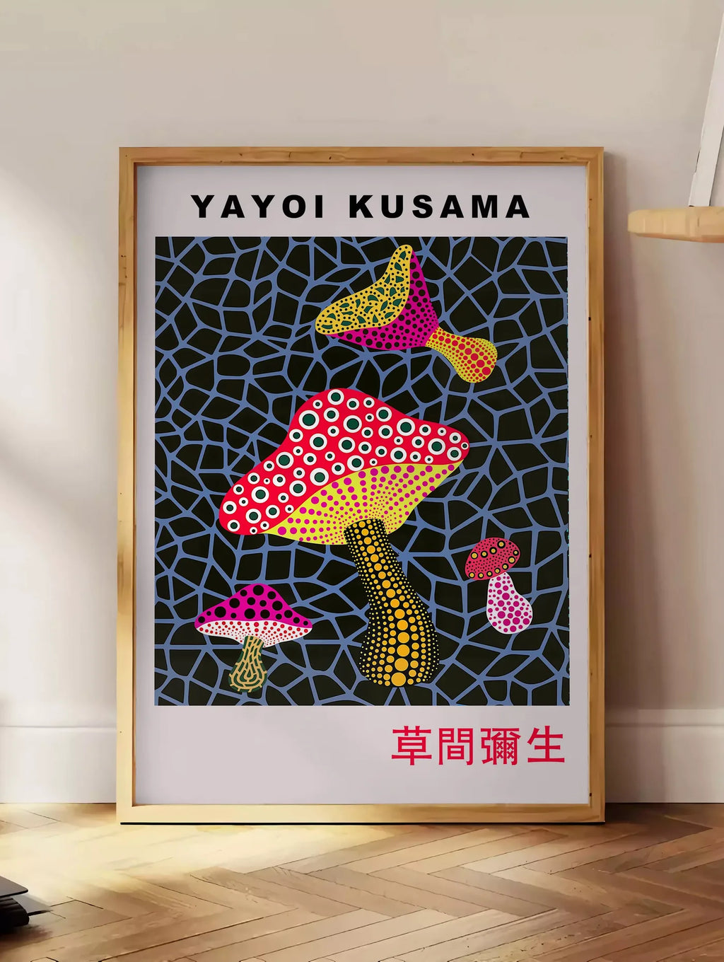 Estampe affiche champignons a pois de Kusama art japonais, posee au sol dans un coin salon, sur un parquet a chevrons, pres d'une table d'appoint en chene chargee de livres