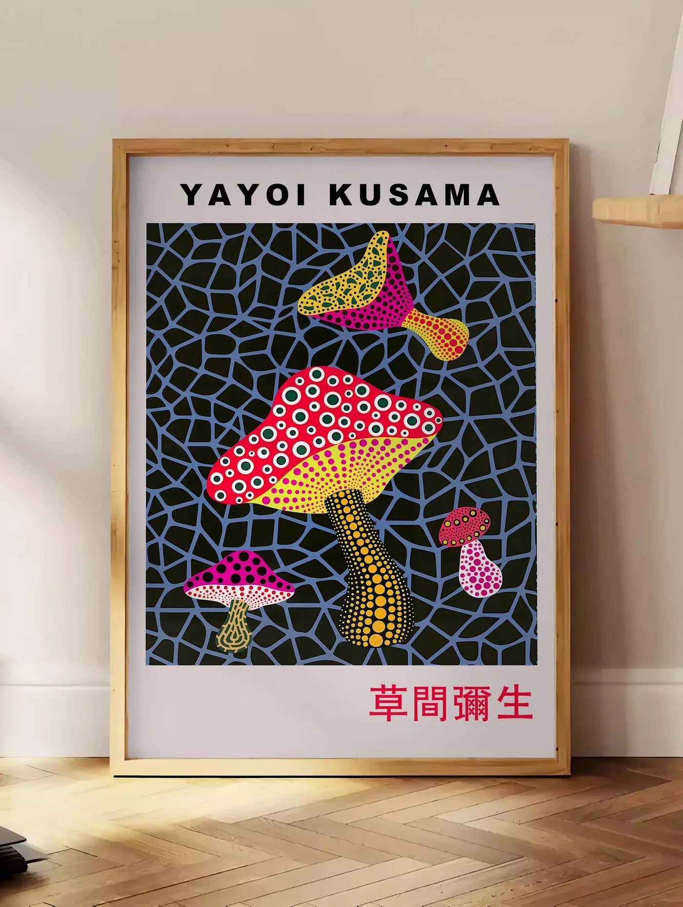 Estampe affiche champignons a pois de Kusama art japonais, posee au sol dans un coin salon, sur un parquet a chevrons, pres d'une table d'appoint en chene chargee de livres