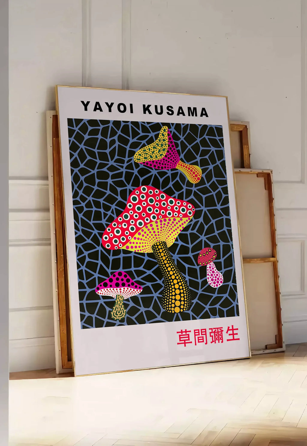 Tirage encadrable affiche champignons a pois de Kusama art japonais, posee au sol dans une entree lumineuse, contre un mur a panneaux blancs, a cote de chassis en bois empiles