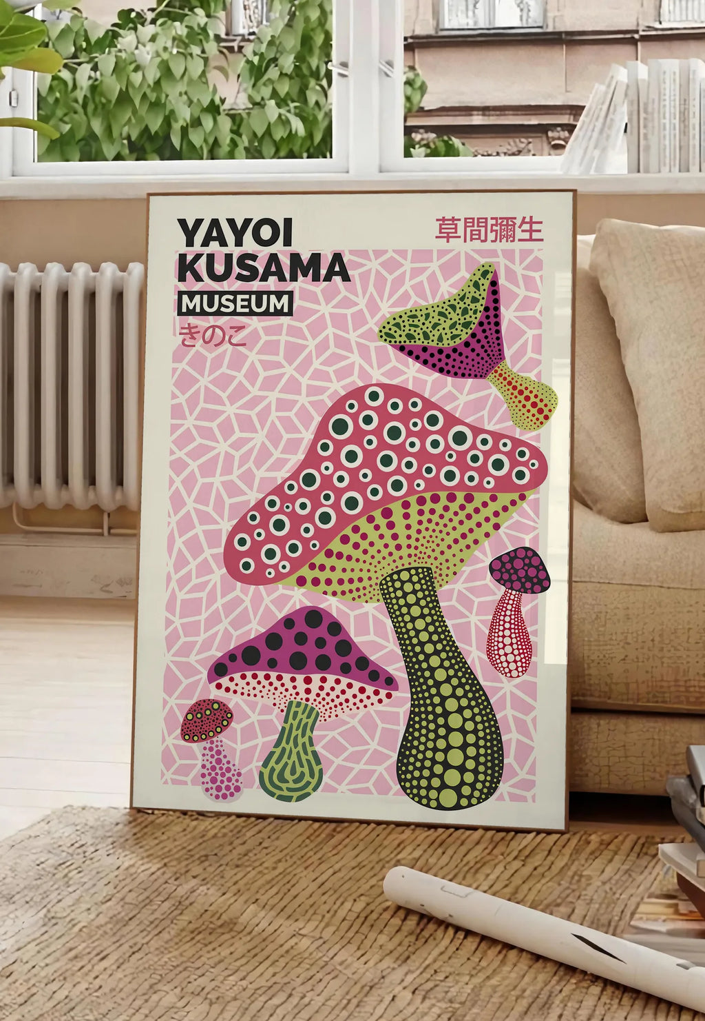 Poster affiche champignons multicolores de Kusama art japonais, posee au sol dans un salon parisien, devant une grande fenetre donnant sur un immeuble haussmannien, entre un ficus et un canape creme