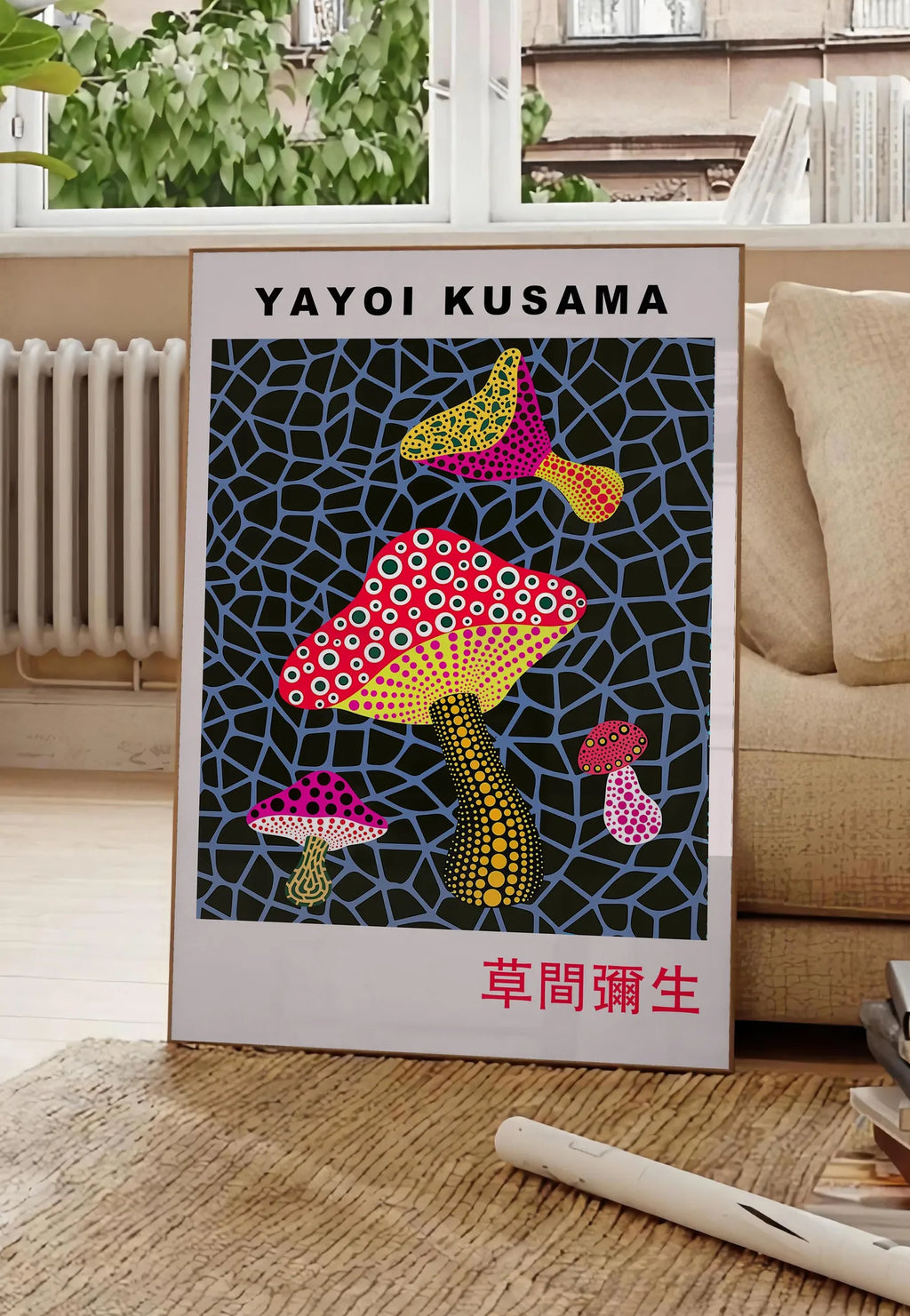 Poster affiche champignons rouge de Kusama art japonais, posee au sol dans un salon parisien, devant une grande fenetre donnant sur un immeuble haussmannien, entre un ficus et un canape creme