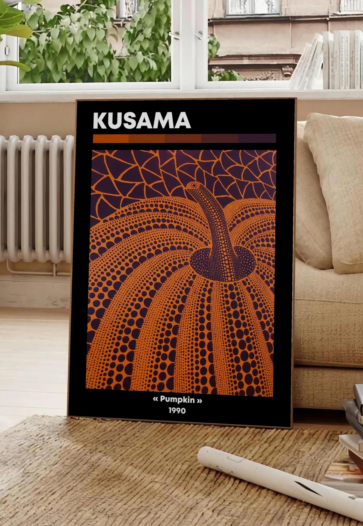 Poster affiche Kusama citrouille orange a pois vue en contre-plongee sur fond violet, posee au sol dans un salon parisien, devant une grande fenetre donnant sur un immeuble haussmannien, entre un ficus et un canape creme