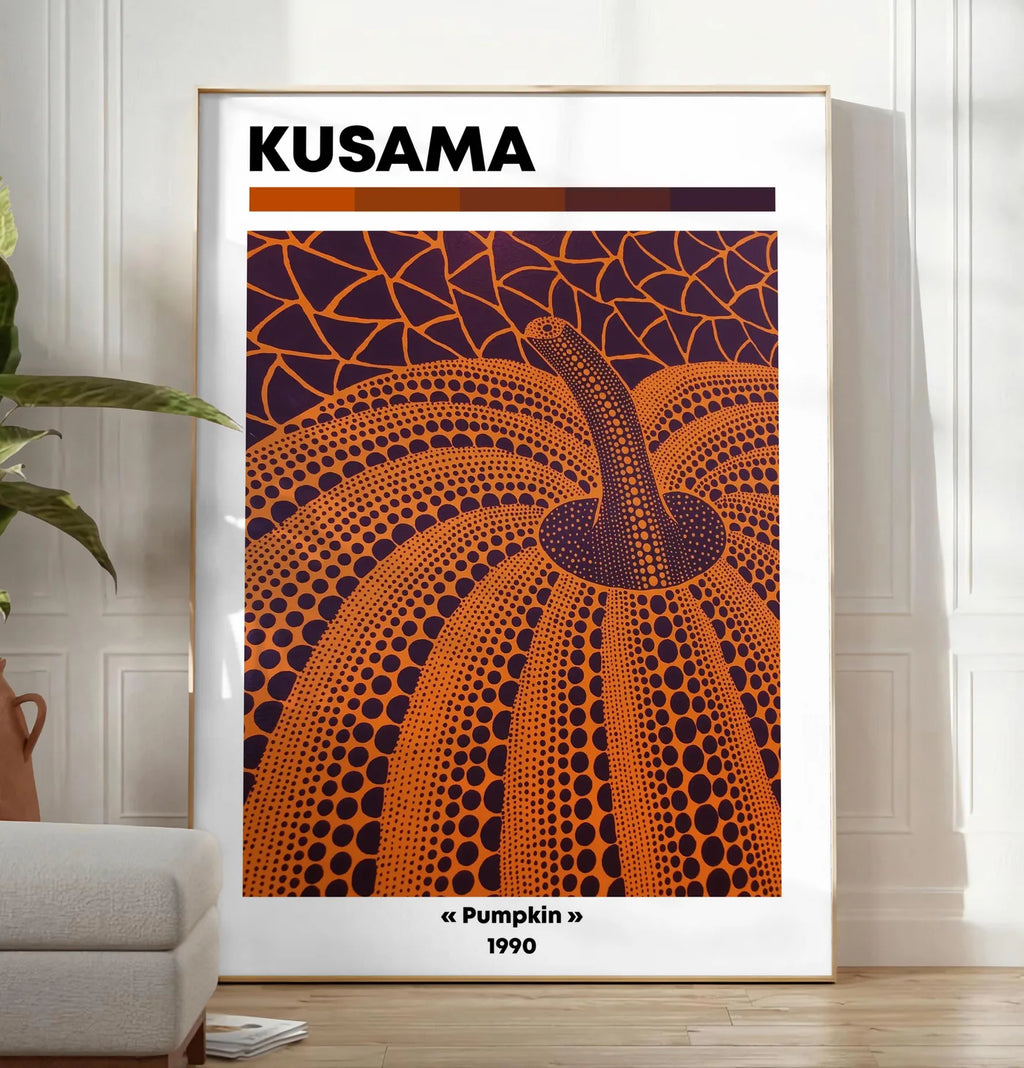 Reproduction affiche Kusama citrouille orange feu a pois sur fond aubergine, posee au sol dans un salon minimaliste clair, a cote d'un canape beige et d'une plante verte, sur un parquet clair