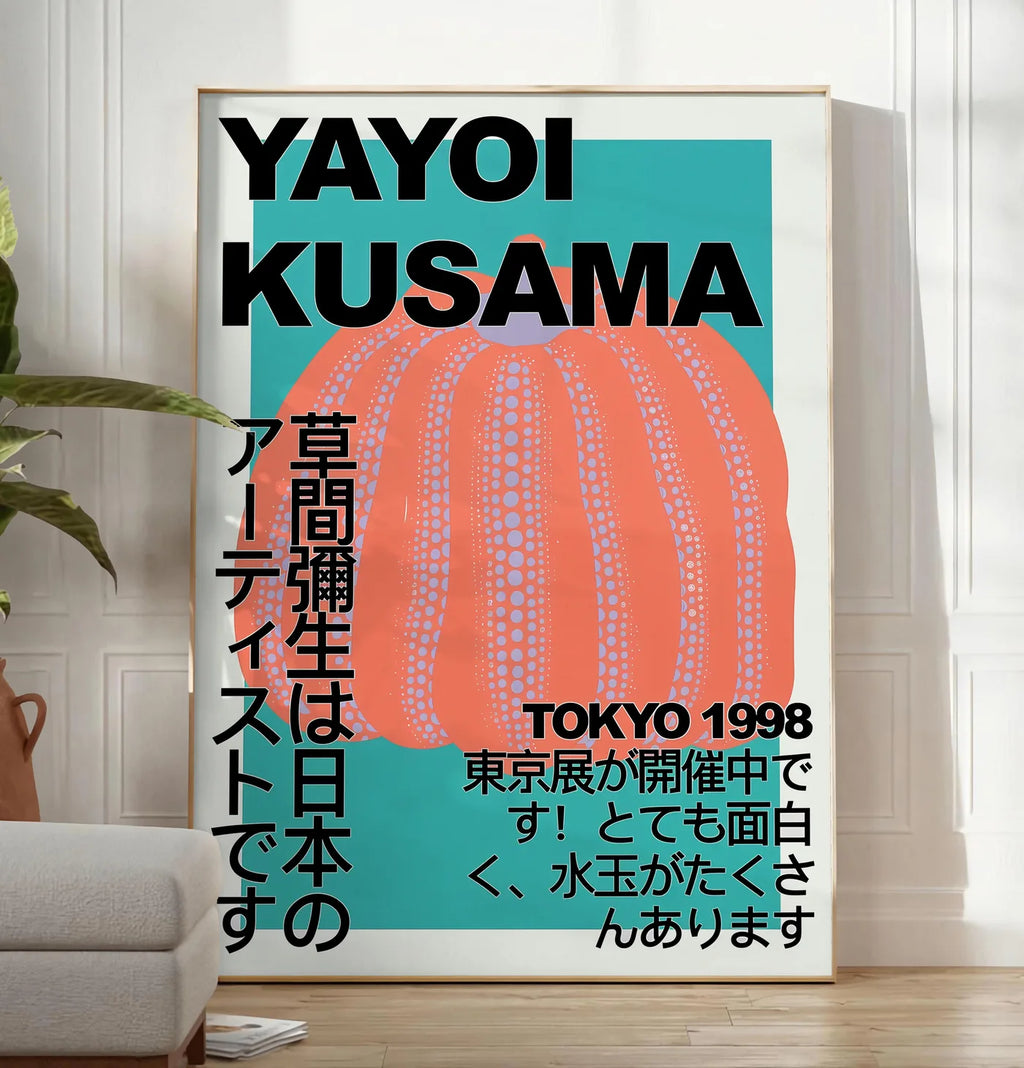 Reproduction affiche citrouille orange de Kusama art japonais, posee au sol dans un salon minimaliste clair, a cote d'un canape beige et d'une plante verte, sur un parquet clair