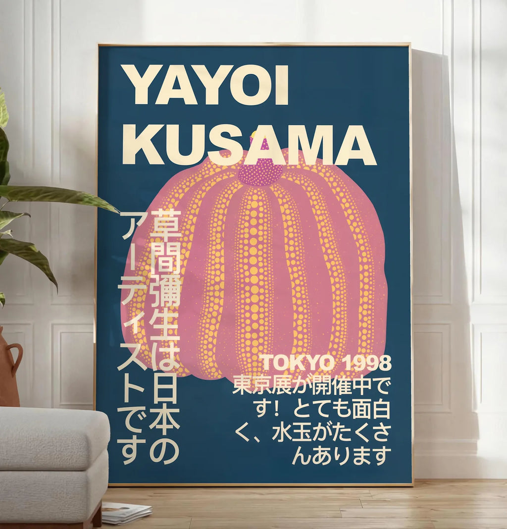Reproduction affiche Kusama citrouille rose a pois sur fond bleu nuit, posee au sol dans un salon minimaliste clair, a cote d'un canape beige et d'une plante verte, sur un parquet clair