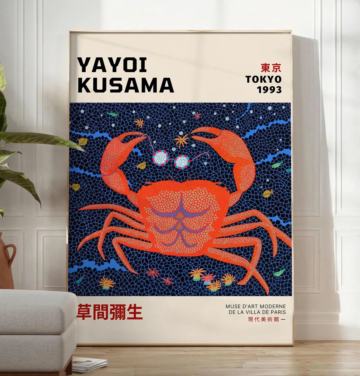 Reproduction affiche crabe rouge a pois de Kusama art japonais, posee au sol dans un salon minimaliste clair, a cote d'un canape beige et d'une plante verte, sur un parquet clair