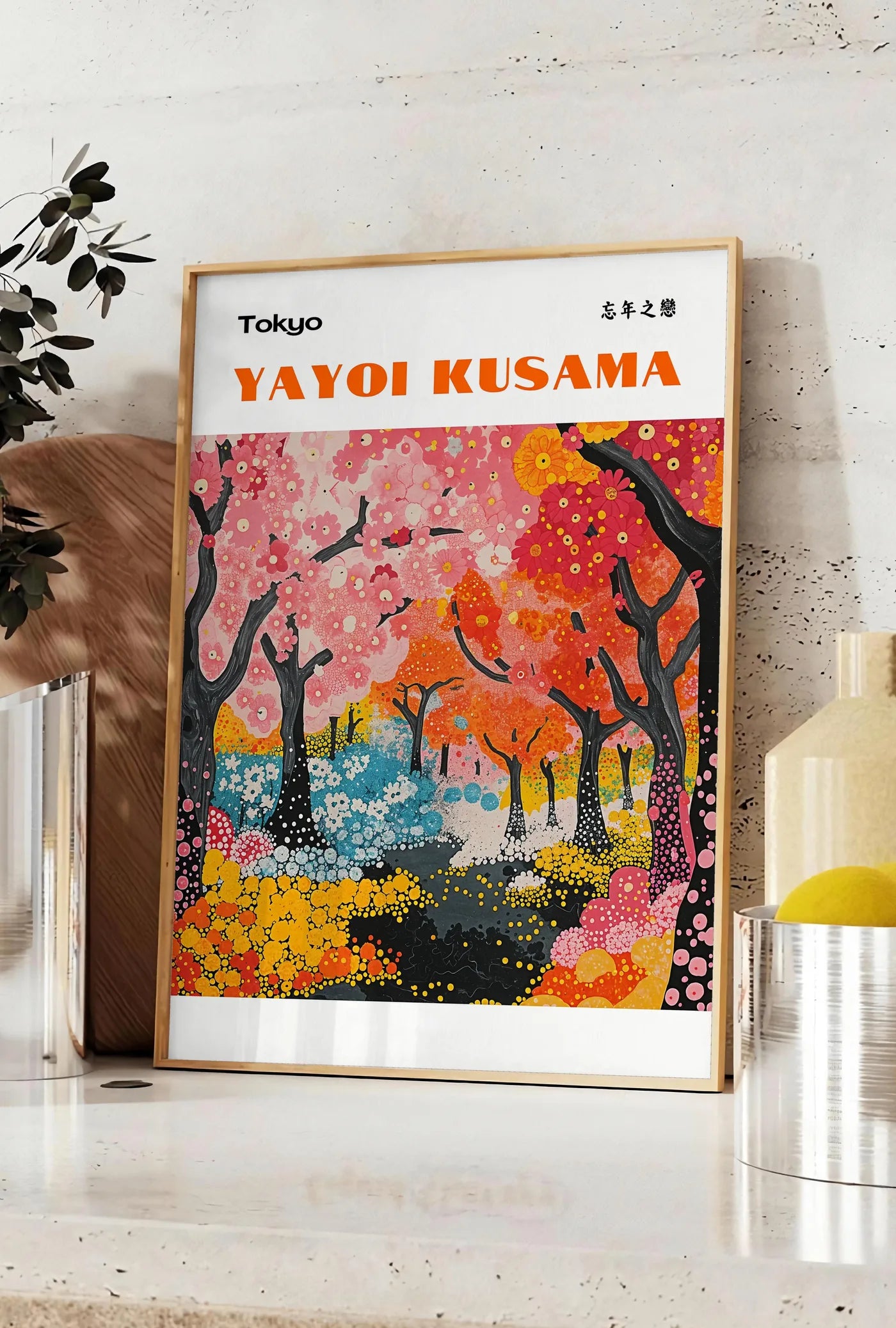 Affiche affiche foret printaniere de Kusama art japonais, posee sur un plan de travail de cuisine en pierre claire, entre une branche d'eucalyptus en vase et un bocal de citrons