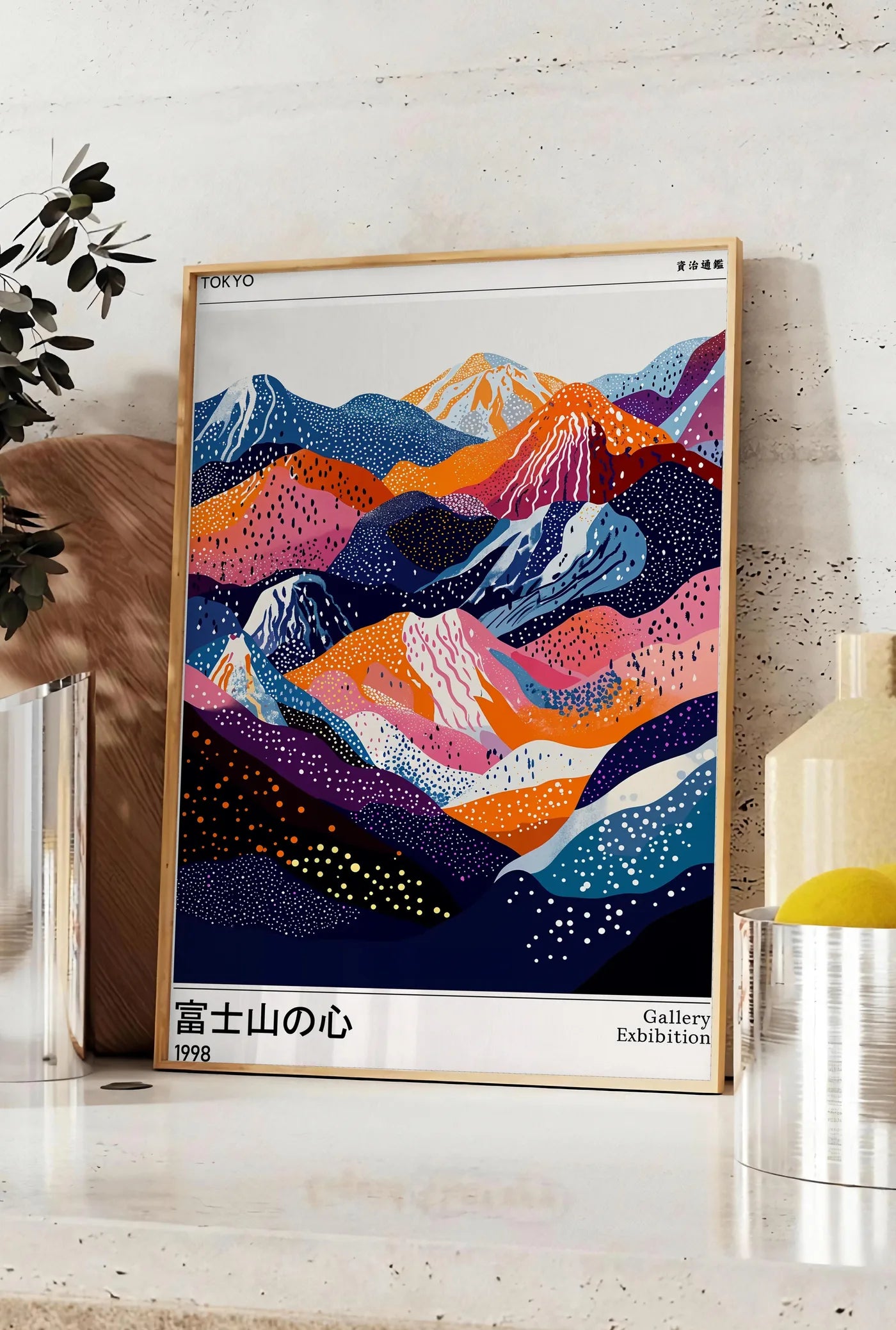 Affiche affiche montagnes du Fuji de Kusama art japonais, posee sur un plan de travail de cuisine en pierre claire, entre une branche d'eucalyptus en vase et un bocal de citrons