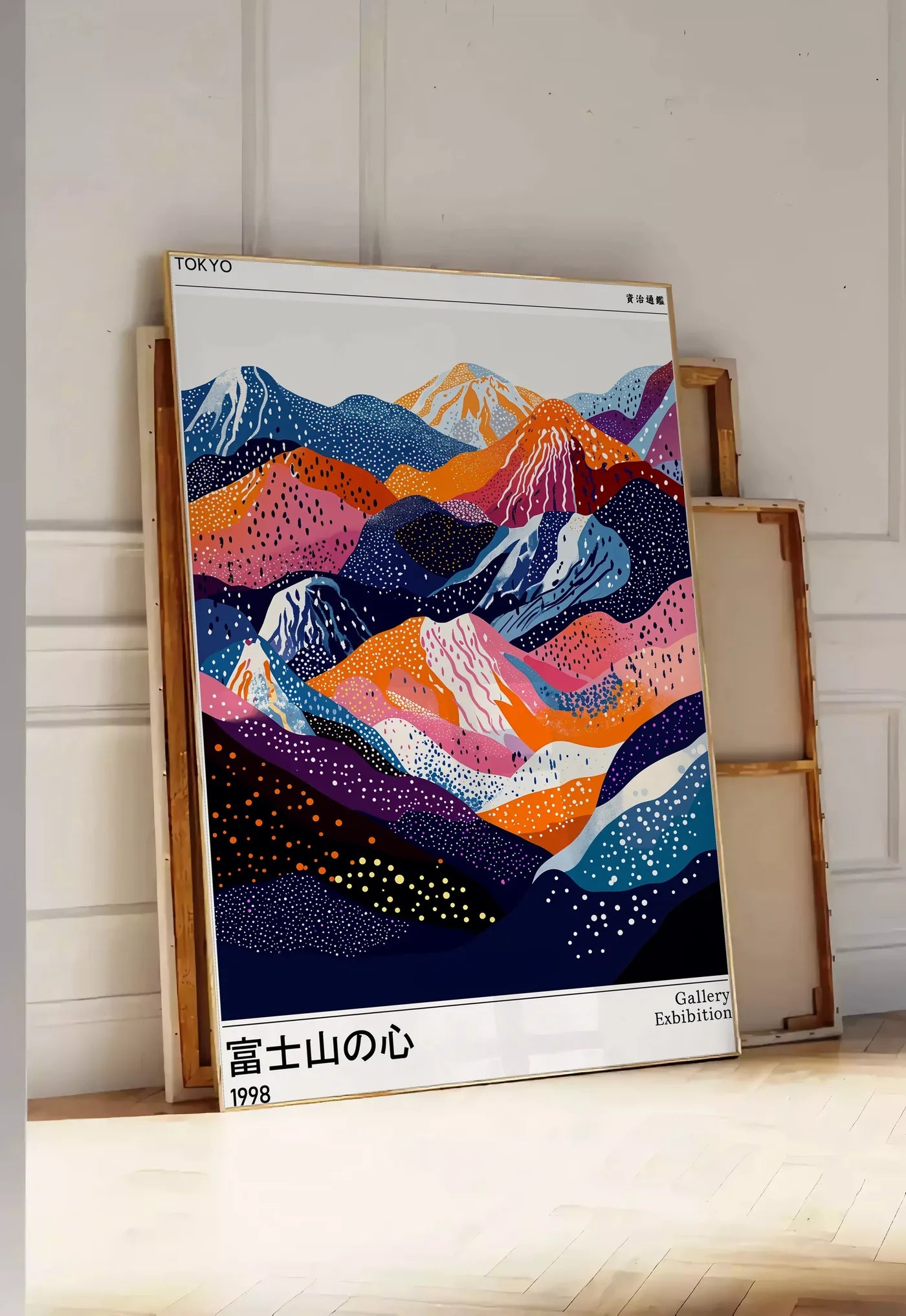Tirage encadrable affiche montagnes du Fuji de Kusama art japonais, posee au sol dans une entree lumineuse, contre un mur a panneaux blancs, a cote de chassis en bois empiles