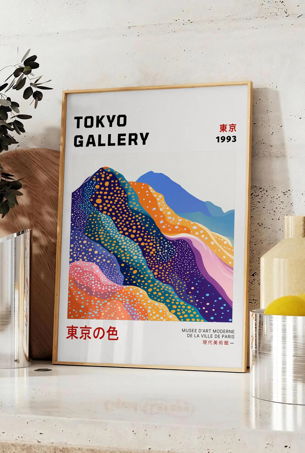 Affiche affiche montagnes Fuji de Kusama art japonais, posee sur un plan de travail de cuisine en pierre claire, entre une branche d'eucalyptus en vase et un bocal de citrons