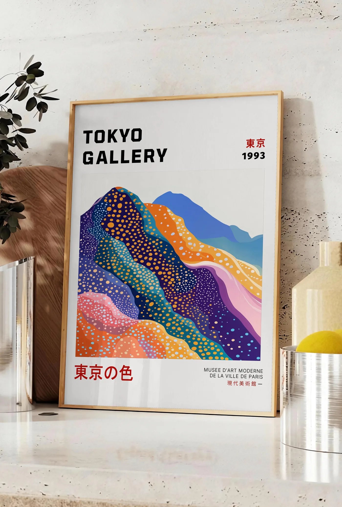 Affiche affiche montagnes Fuji de Kusama art japonais, posee sur un plan de travail de cuisine en pierre claire, entre une branche d'eucalyptus en vase et un bocal de citrons