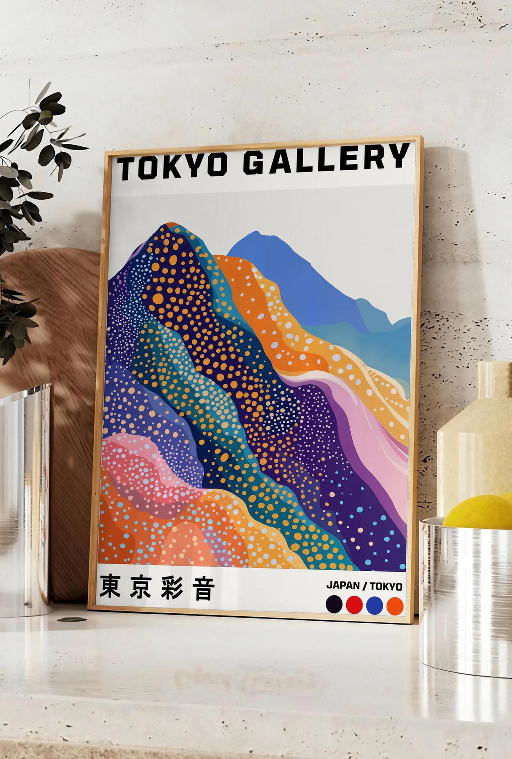 Affiche affiche montagnes Fuji de Kusama art japonais, posee sur un plan de travail de cuisine en pierre claire, entre une branche d'eucalyptus en vase et un bocal de citrons