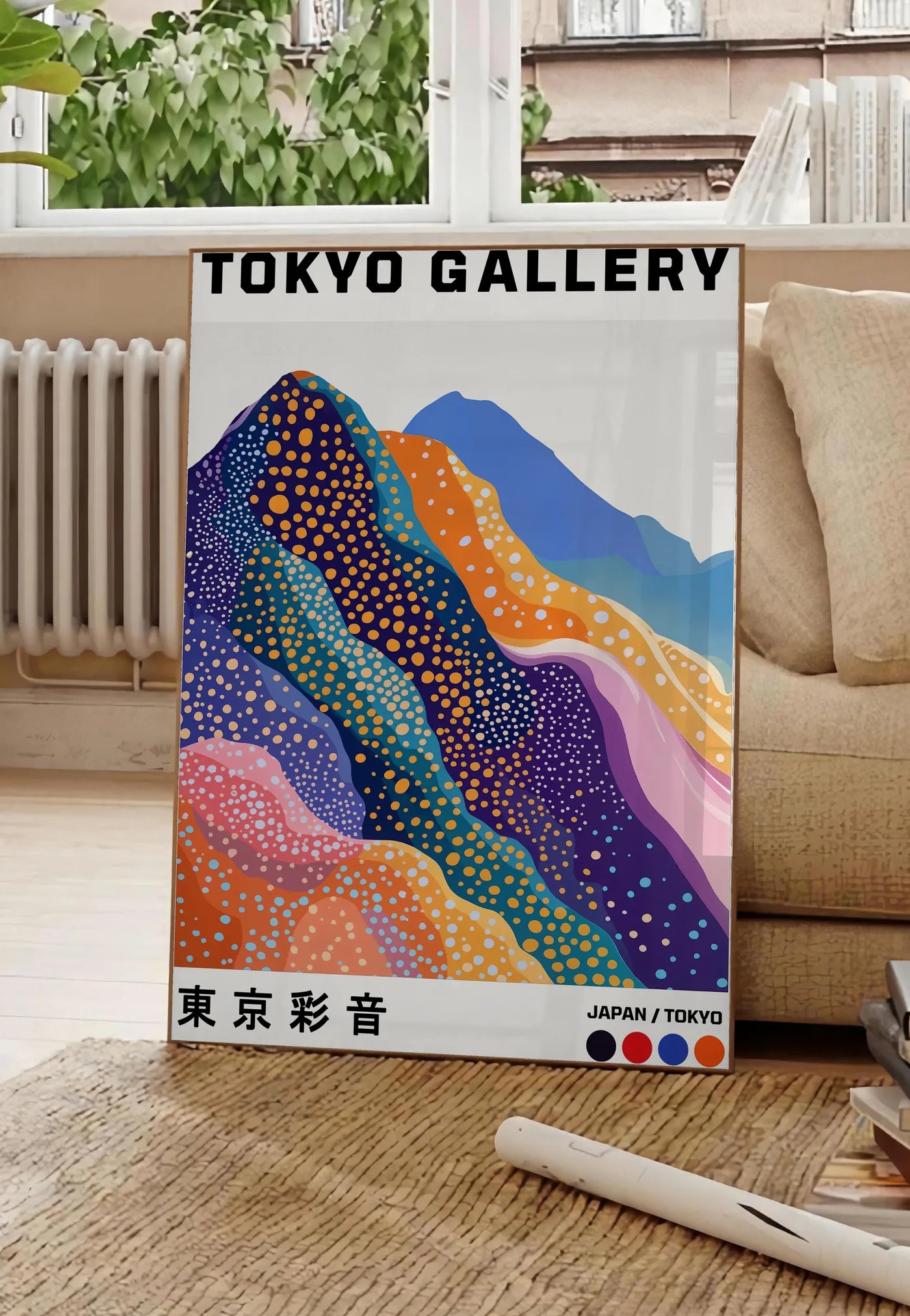 Poster affiche montagnes Fuji de Kusama art japonais, posee au sol dans un salon parisien, devant une grande fenetre donnant sur un immeuble haussmannien, entre un ficus et un canape creme