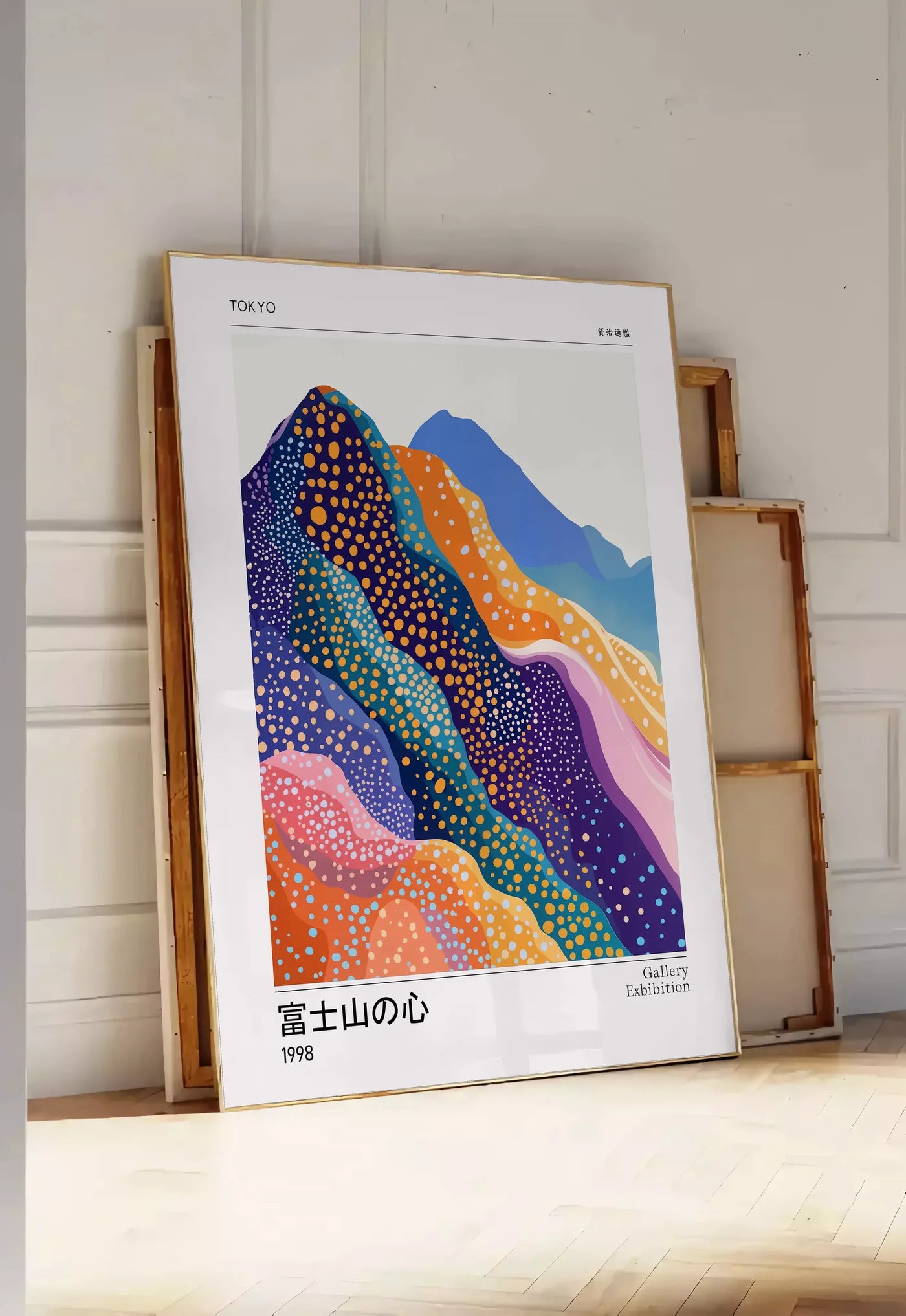 Tirage encadrable affiche montagnes Fuji de Kusama art japonais, posee au sol dans une entree lumineuse, contre un mur a panneaux blancs, a cote de chassis en bois empiles