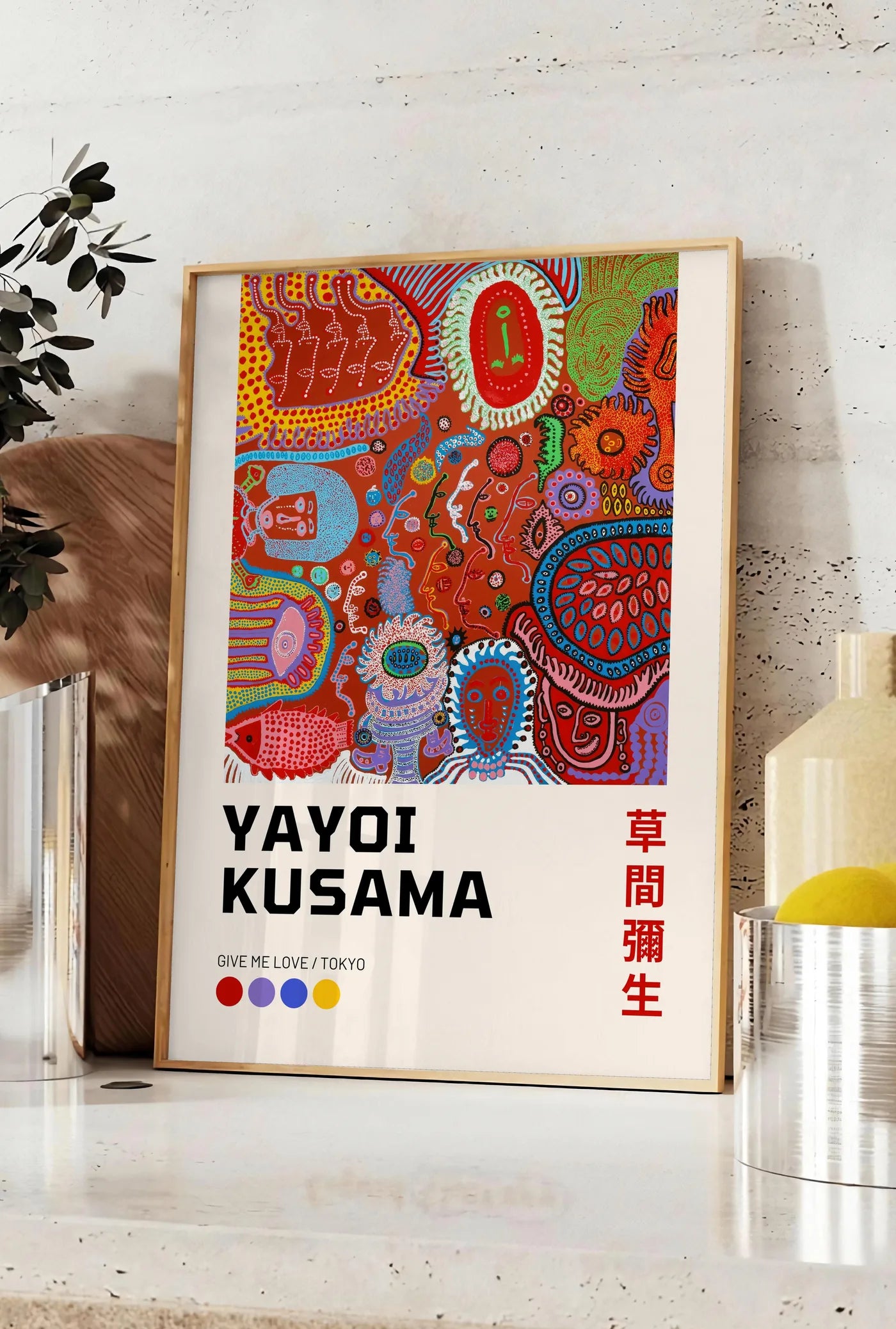 Affiche affiche composition a pois de Kusama art japonais, posee sur un plan de travail de cuisine en pierre claire, entre une branche d'eucalyptus en vase et un bocal de citrons