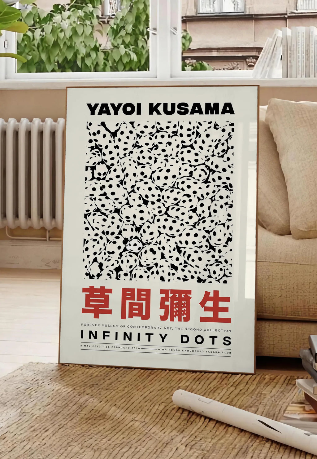 Poster affiche pois noir et blanc de Kusama art japonais, posee au sol dans un salon parisien, devant une grande fenetre donnant sur un immeuble haussmannien, entre un ficus et un canape creme