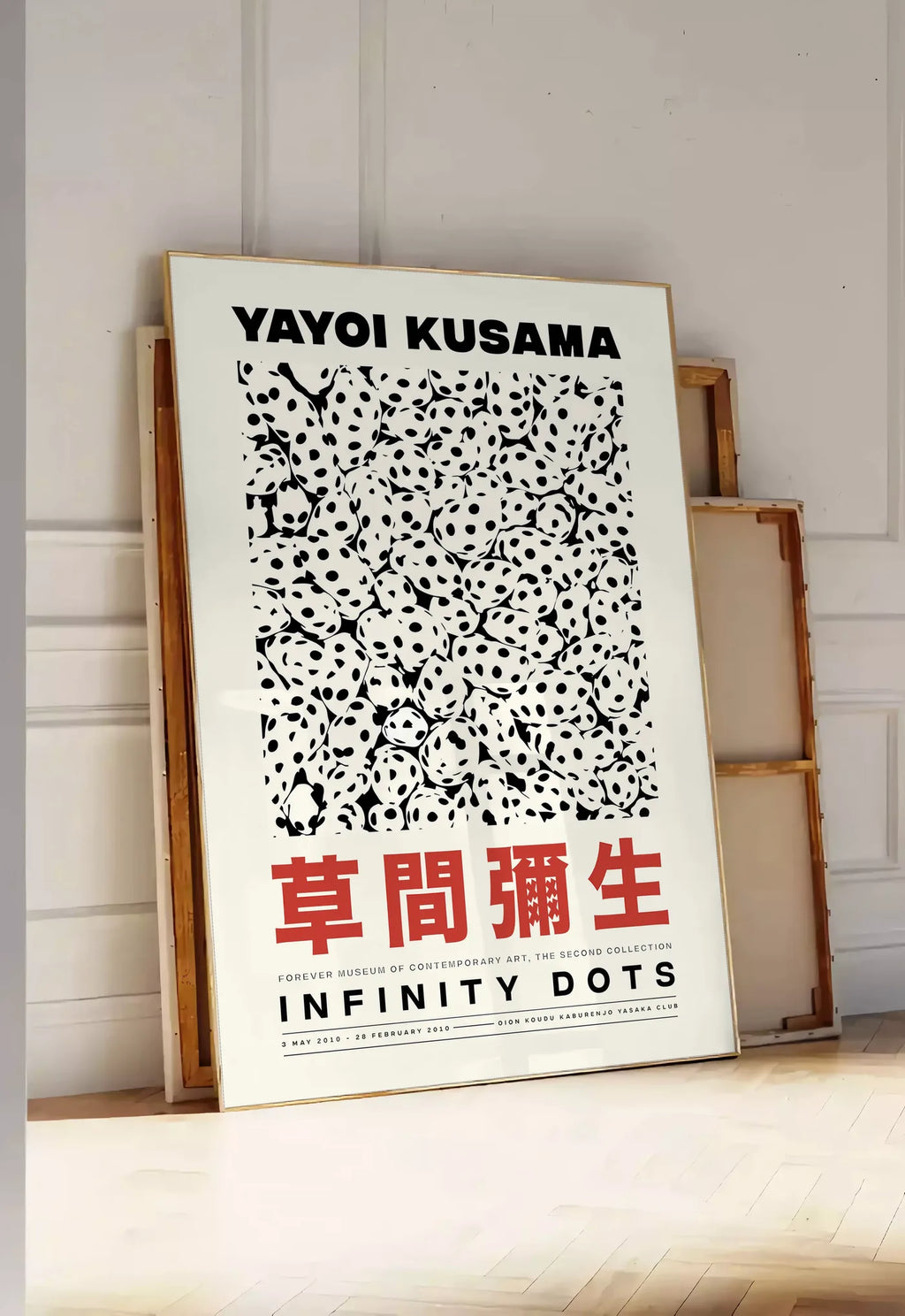 Tirage encadrable affiche pois noir et blanc de Kusama art japonais, posee au sol dans une entree lumineuse, contre un mur a panneaux blancs, a cote de chassis en bois empiles