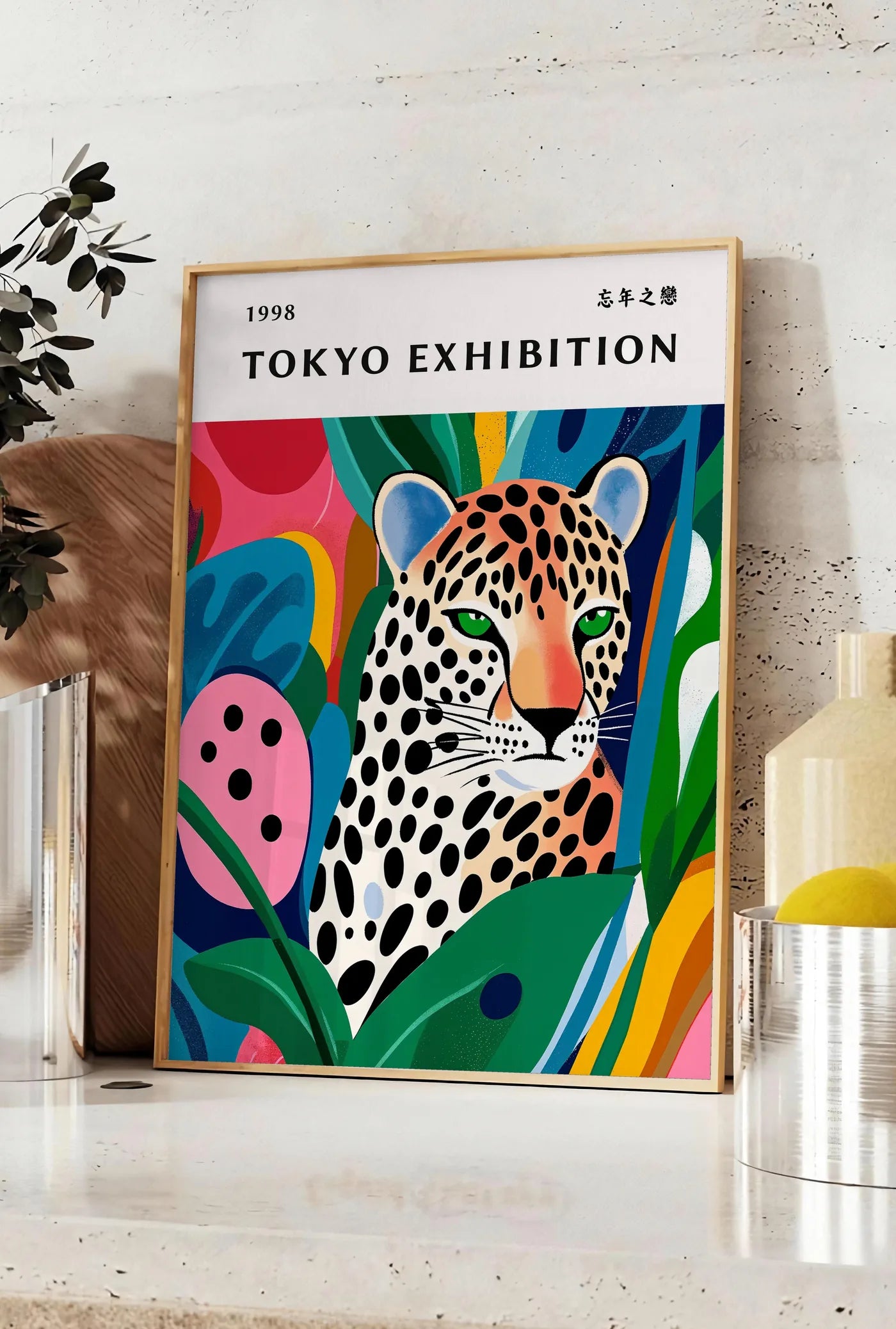 Affiche affiche leopard tachete de Kusama art japonais, posee sur un plan de travail de cuisine en pierre claire, entre une branche d'eucalyptus en vase et un bocal de citrons
