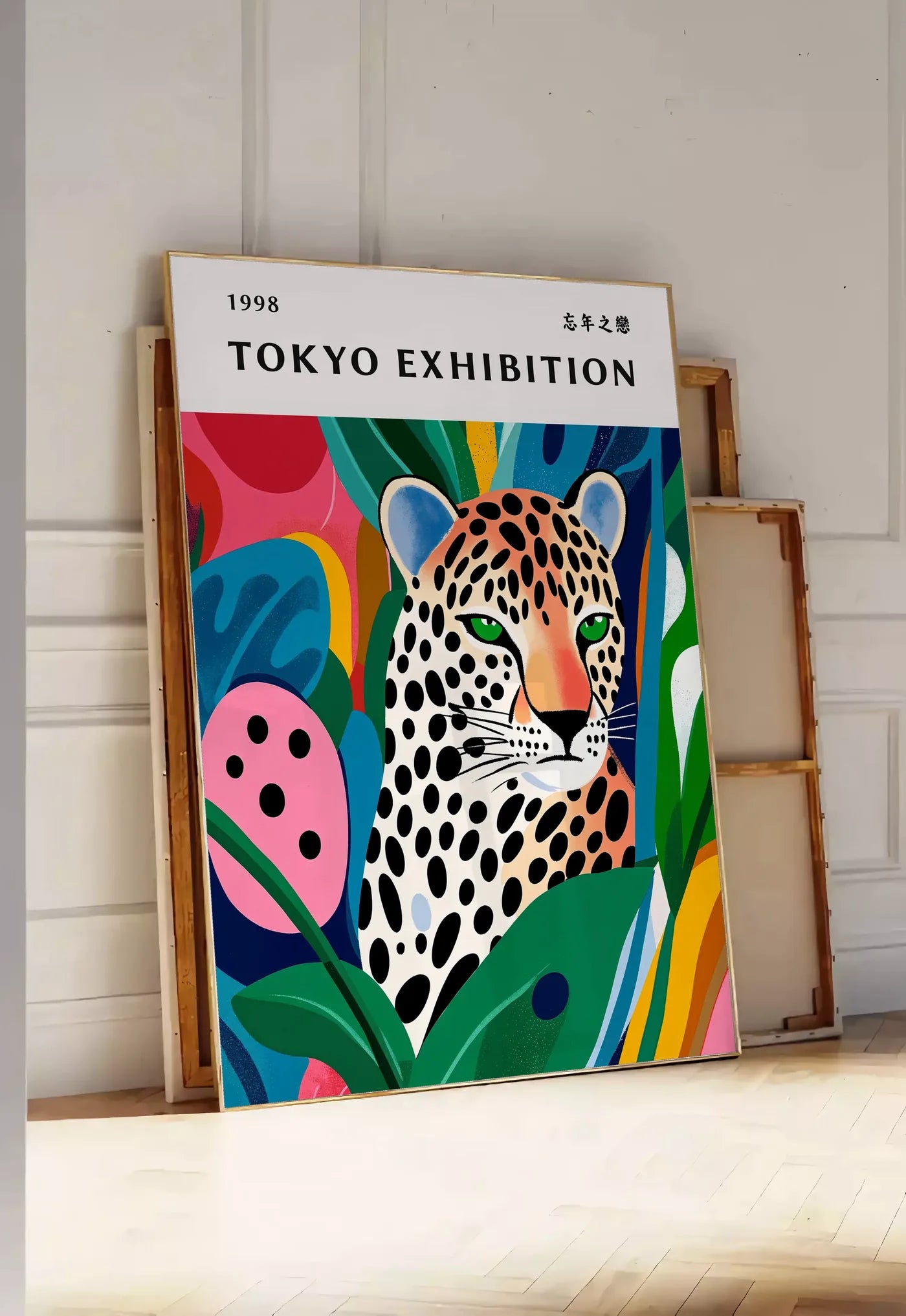 Tirage encadrable affiche leopard tachete de Kusama art japonais, posee au sol dans une entree lumineuse, contre un mur a panneaux blancs, a cote de chassis en bois empiles