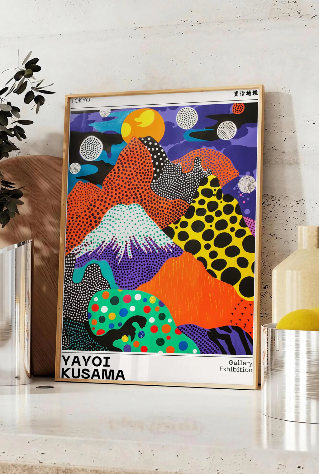 Affiche affiche paysage a pois de Kusama art japonais, posee sur un plan de travail de cuisine en pierre claire, entre une branche d'eucalyptus en vase et un bocal de citrons