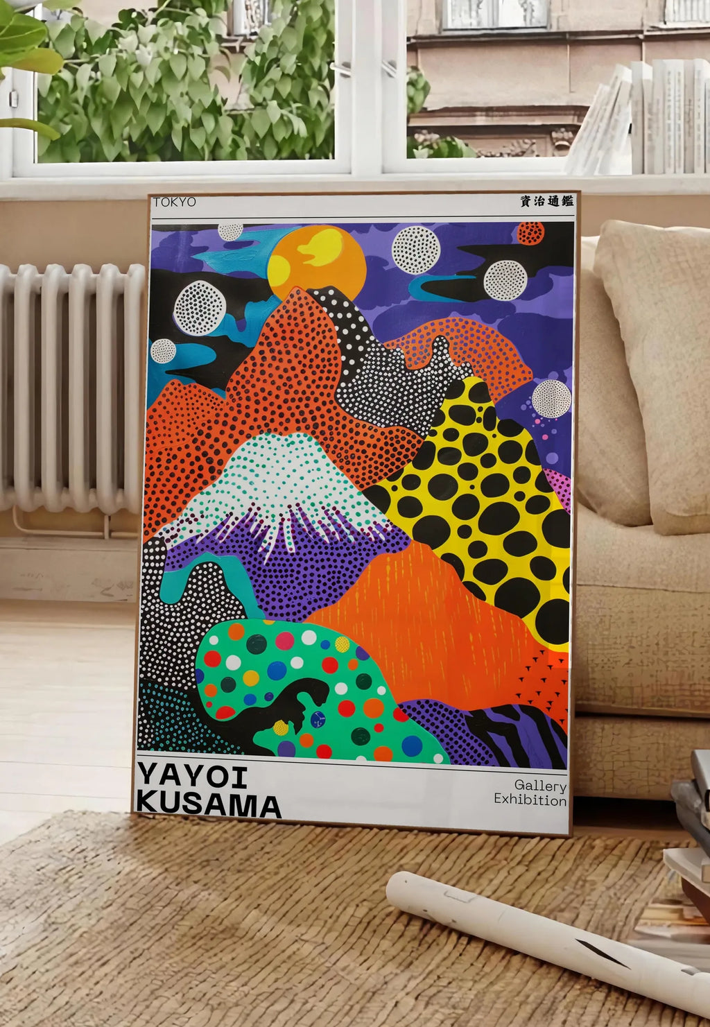 Poster affiche paysage a pois de Kusama art japonais, posee au sol dans un salon parisien, devant une grande fenetre donnant sur un immeuble haussmannien, entre un ficus et un canape creme