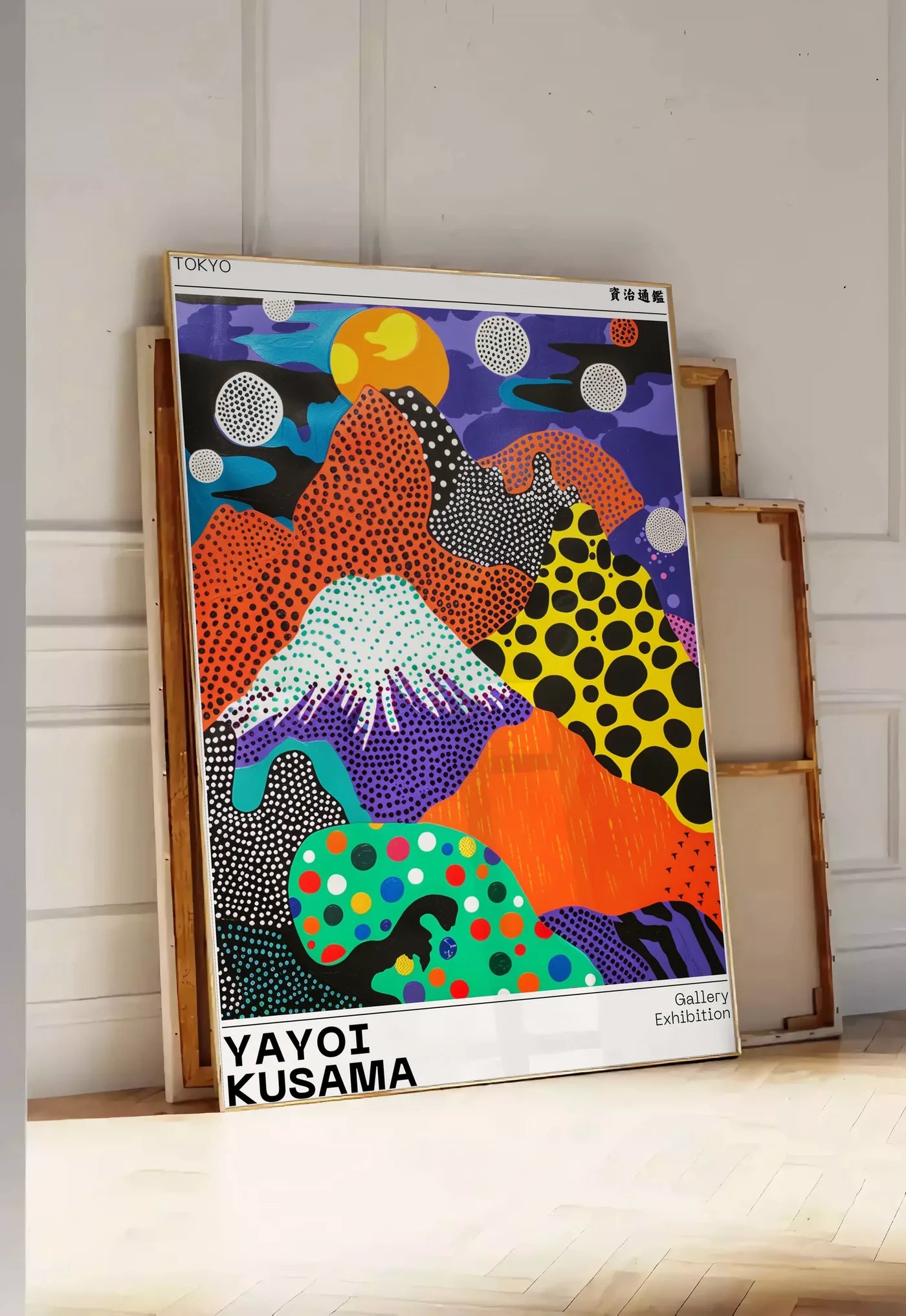 Tirage encadrable affiche paysage a pois de Kusama art japonais, posee au sol dans une entree lumineuse, contre un mur a panneaux blancs, a cote de chassis en bois empiles